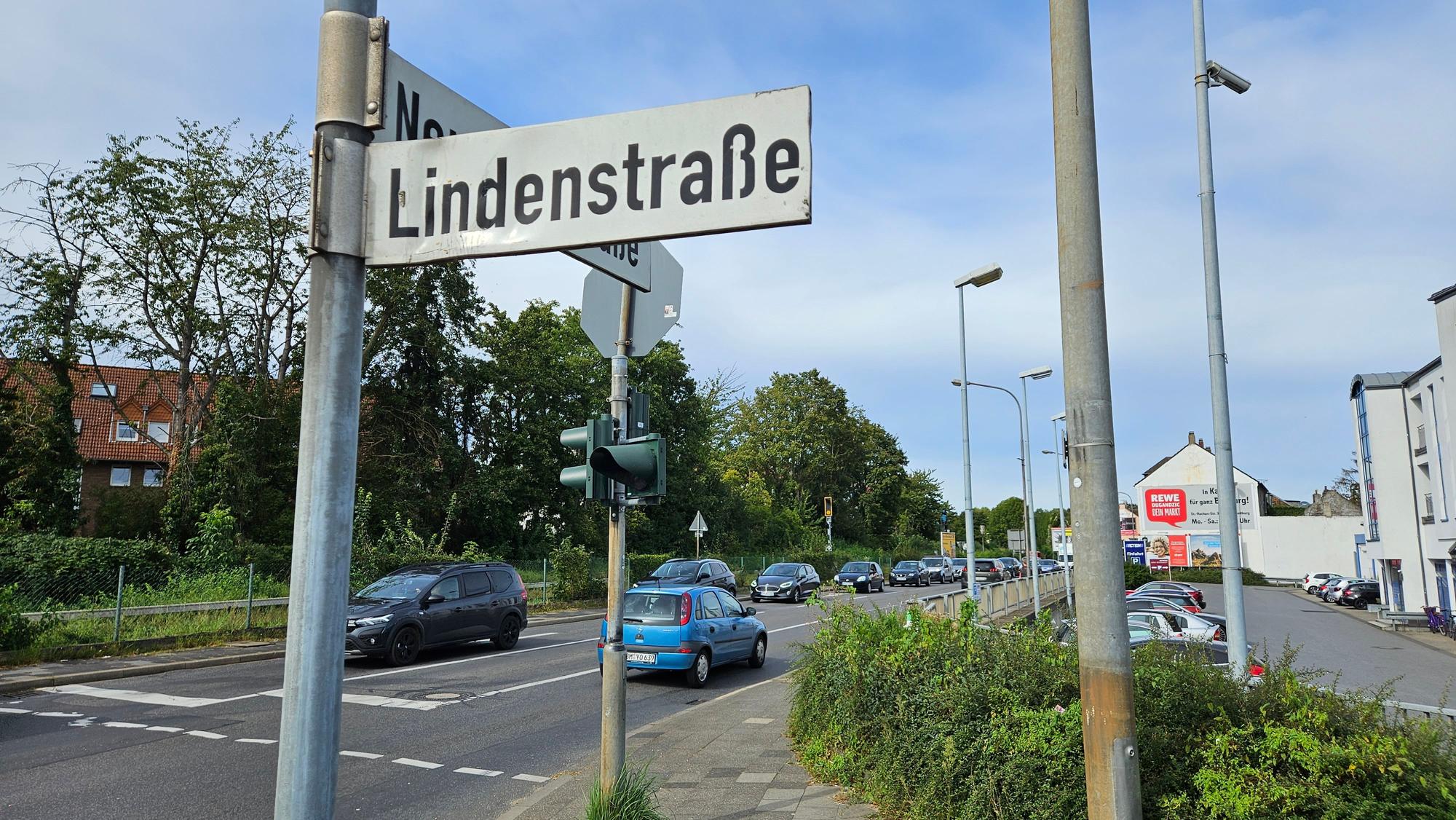 An einer vielbefahrenen Straße steht ein Straßenschild.