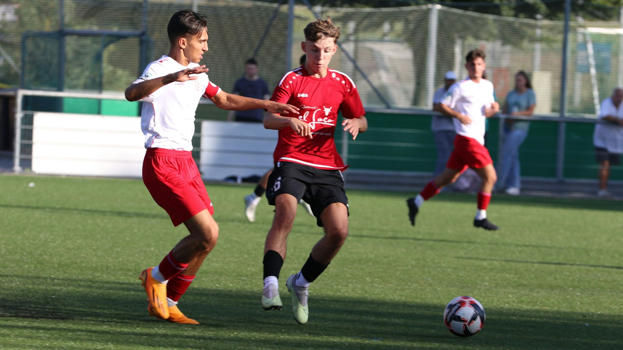 Zwei Fußballspieler versuchen, den Ball zu erlangen.