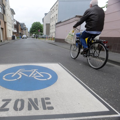Das Foto zeigt einen Fahrradfahrer, der eine Fahrradstraße befährt.