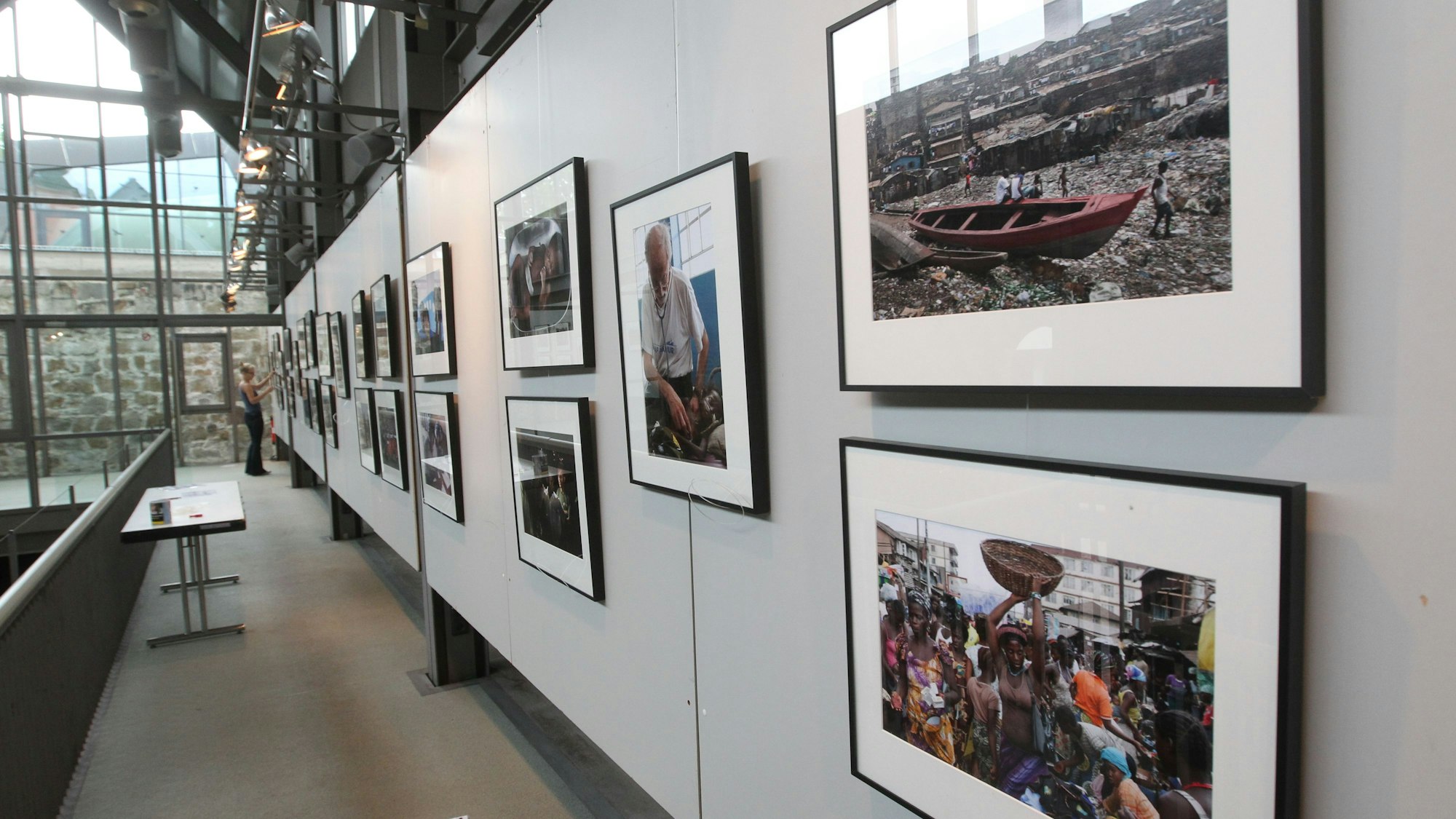 An der Wand der Remise der Burg Wissem hängen gerahmte Fotografien.
