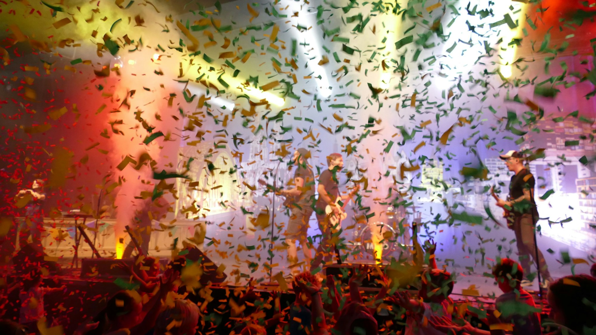 Die Band Miljö steht auf der Bühne und wird von einem Konfetti-Regen verdeckt.