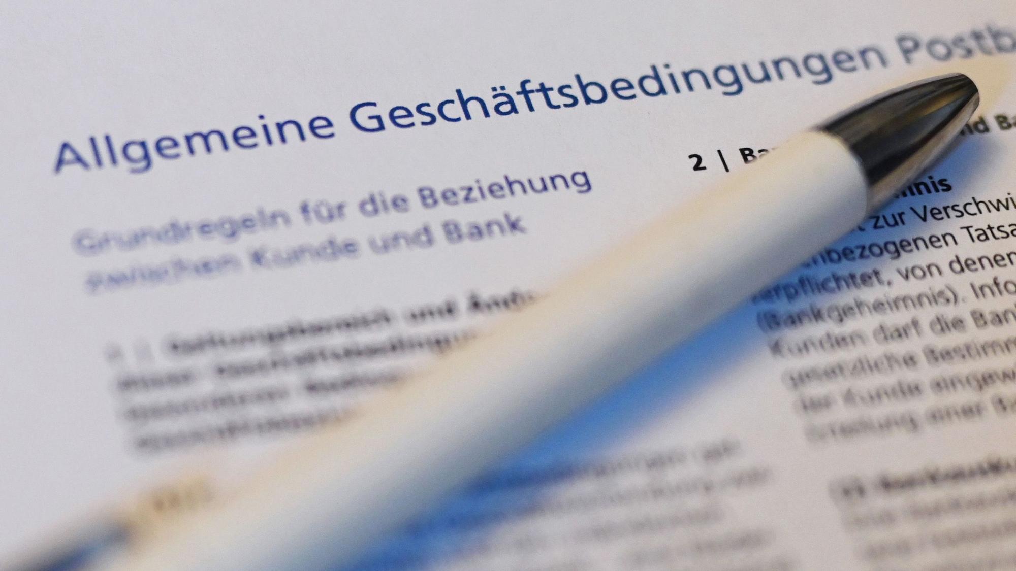 Ein Kugelschreiber liegt auf der ersten Seite der Allgemeine Geschäftsbedingungen (AGB) der Postbank.