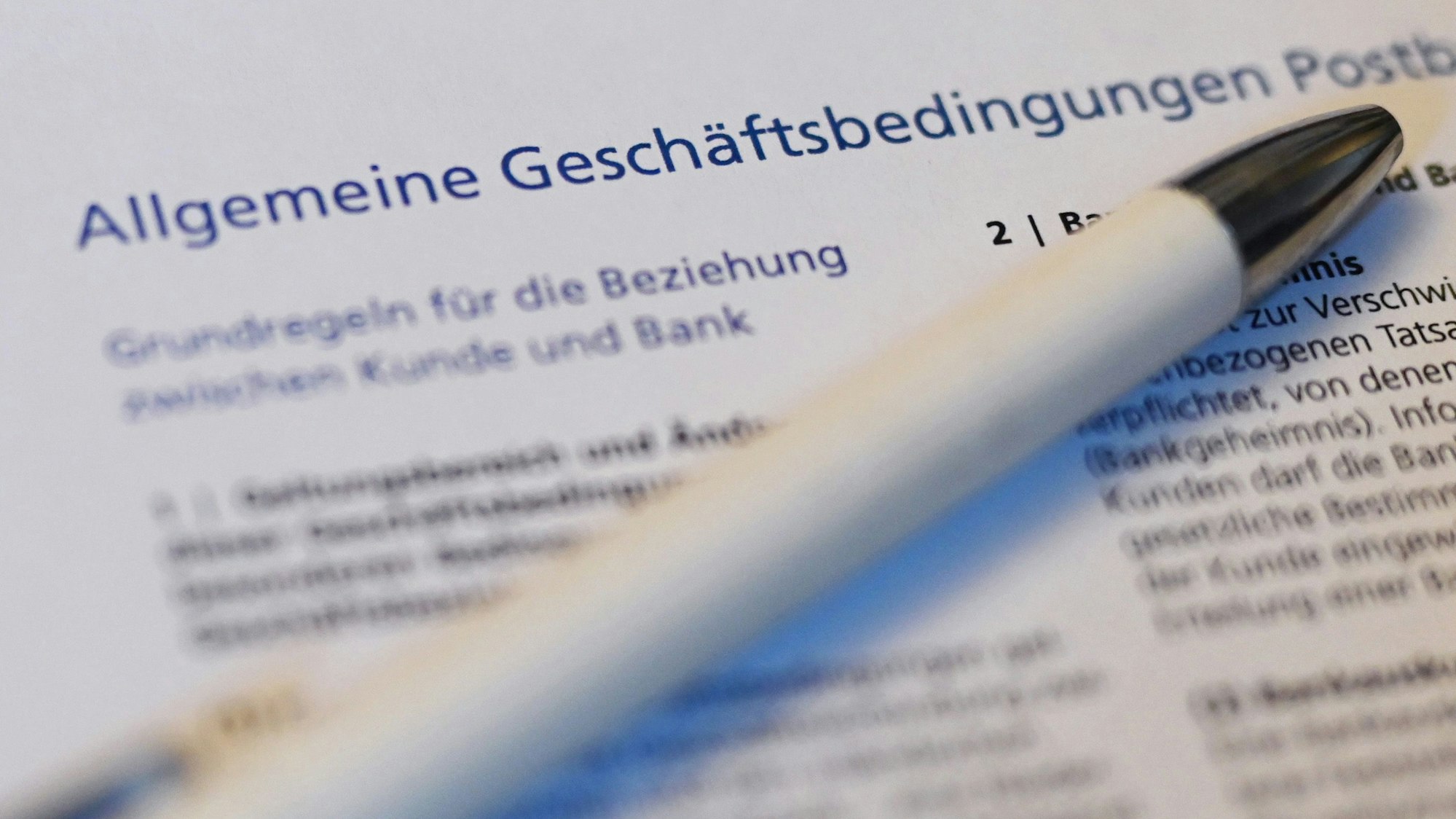 Ein Kugelschreiber liegt auf der ersten Seite der Allgemeine Geschäftsbedingungen (AGB) der Postbank.