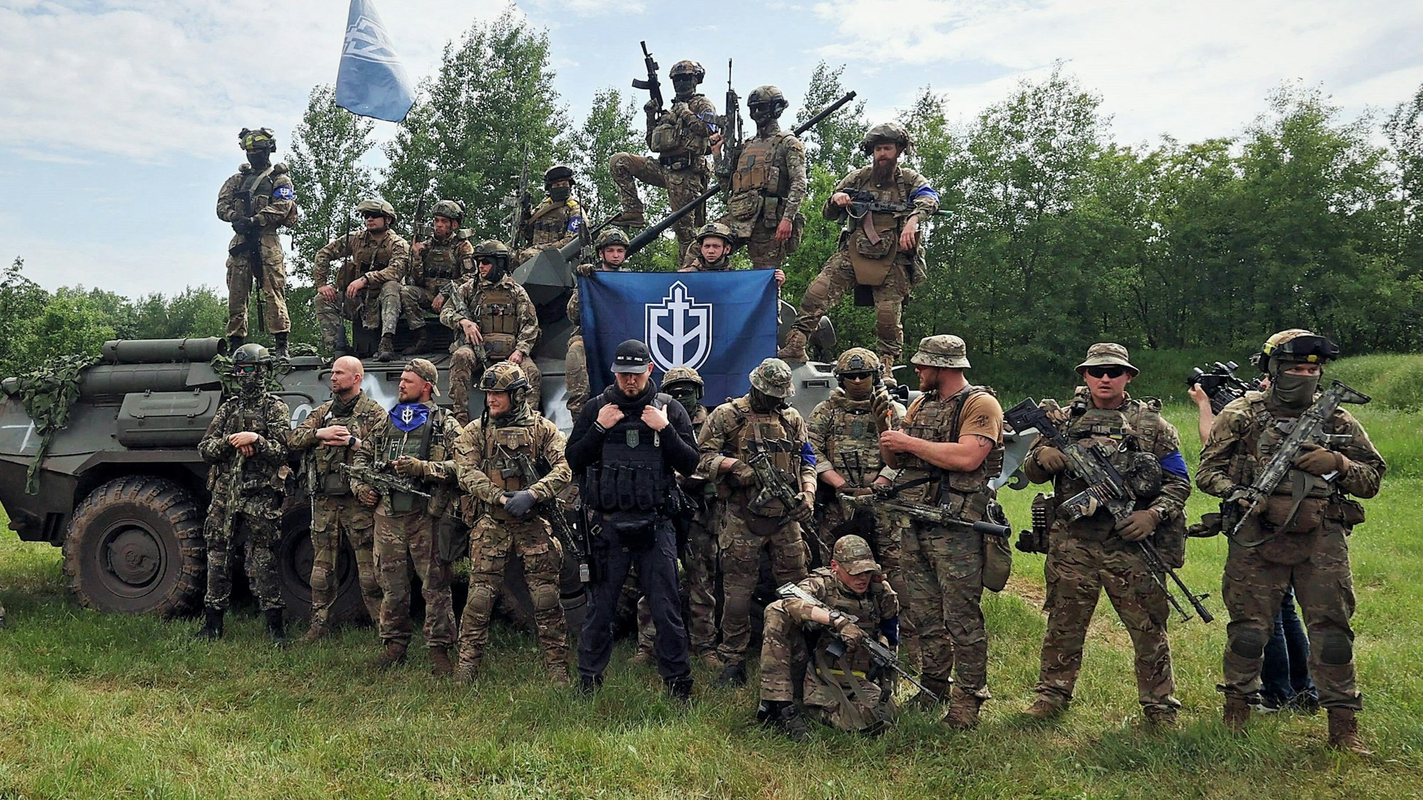 Der russische Neonazi Denis Nikitin (M., schwarze Kleidung) im Gespräch mit Pressevertretern. Im „Guardian“ hat er sich nun zu den Einsätzen seines „Russischen Freiwilligenkorps“ in russischen Grenzregionen geäußert.
