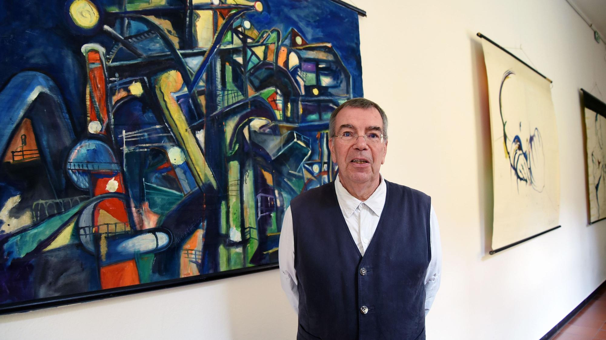 Der Künstler Michael Wittschier steht vor einem seiner Bilder.