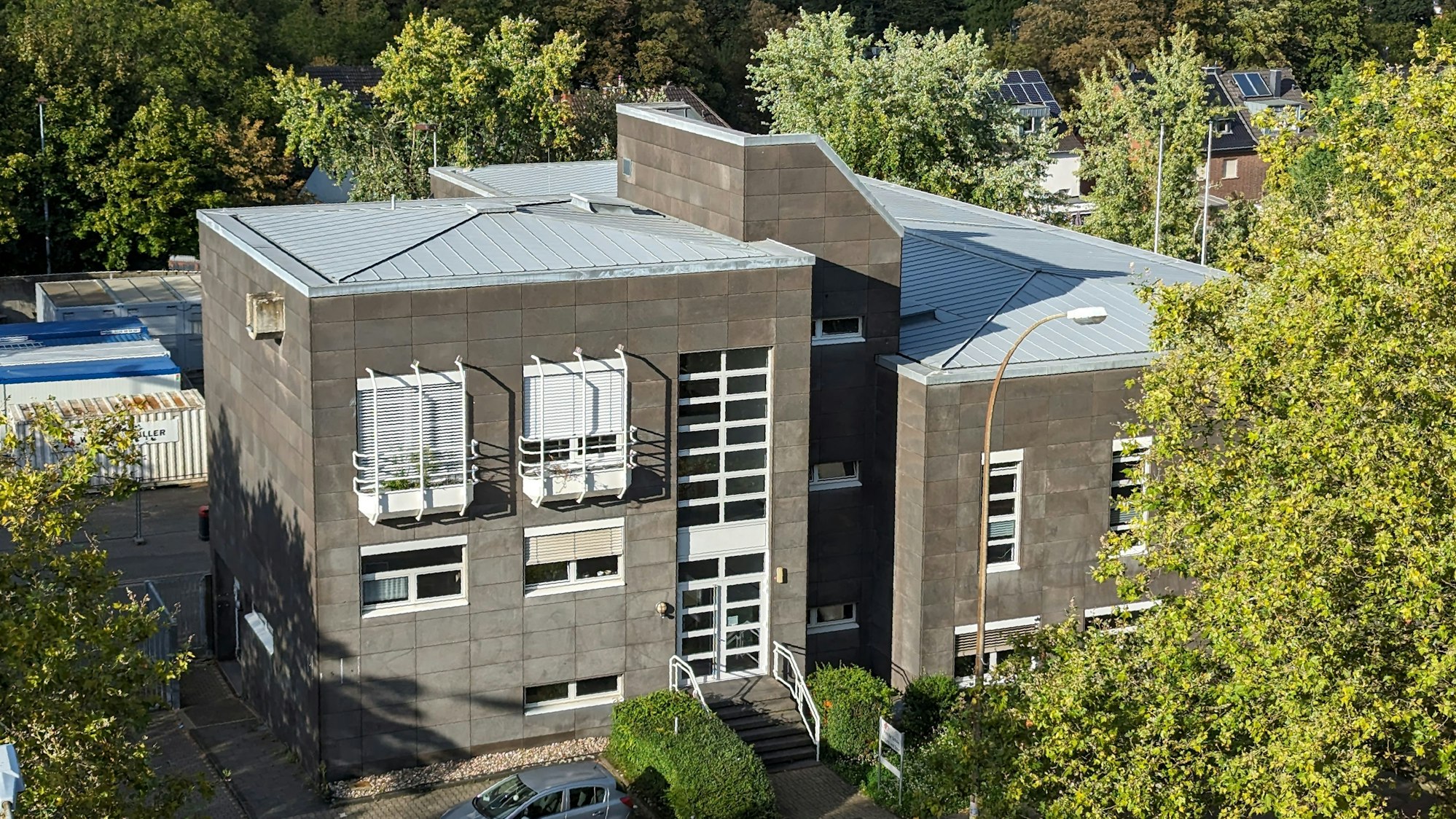 Das ehemalige Postgebäude umgeben von Bäumen.