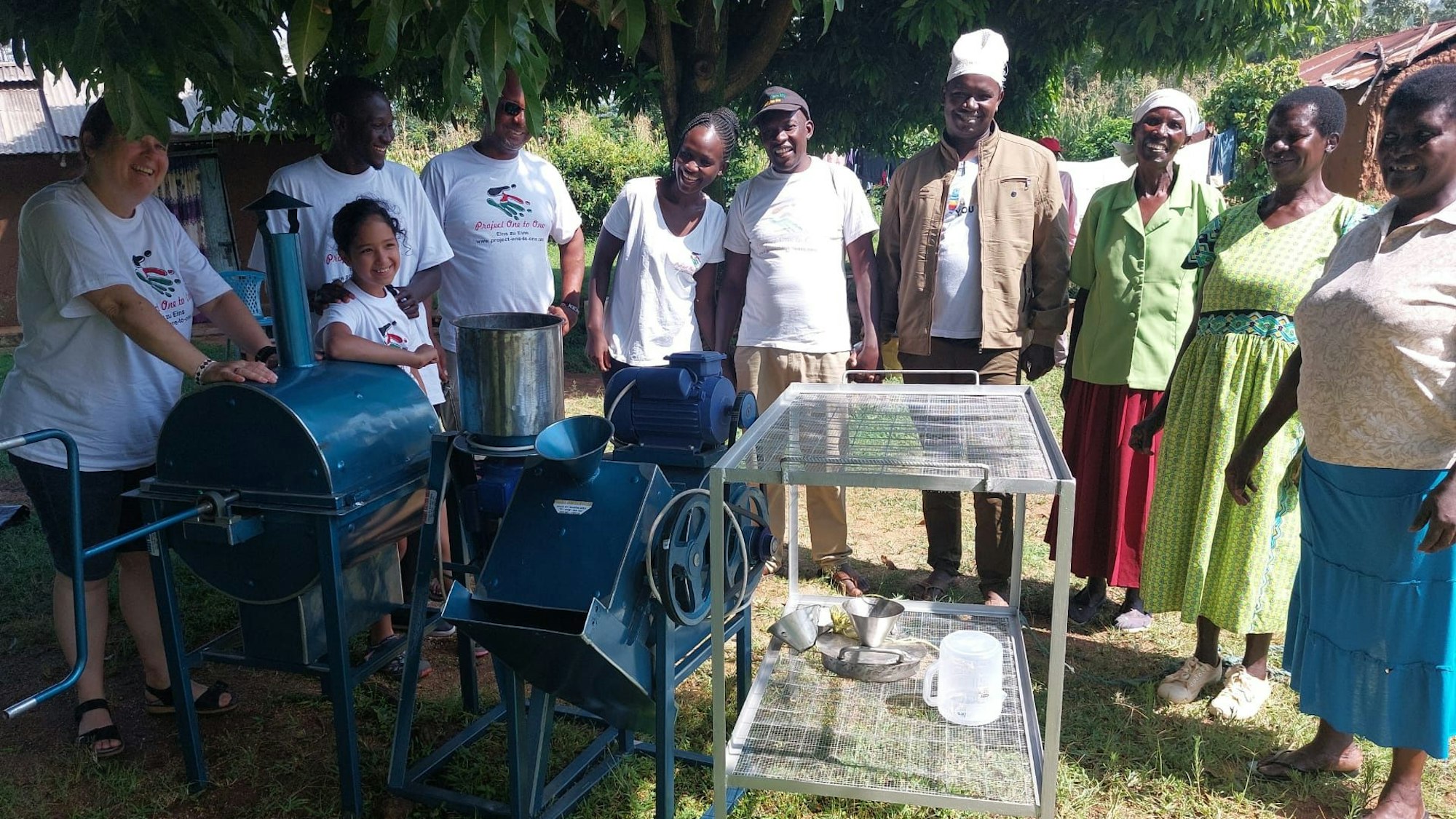 Auf dem Bild sind kenianische Frauen zu sehen, die eine Erdnuss-Maschine geschenkt bekommen haben.