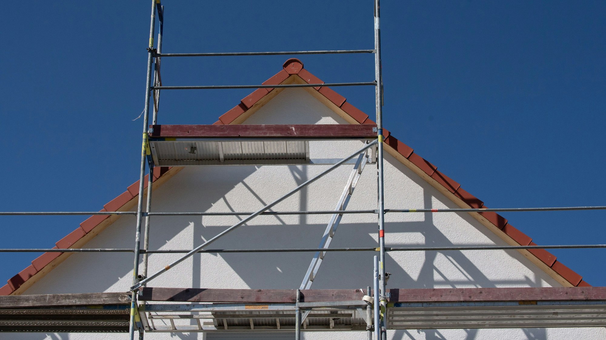 Ein Gerüst steht an einem neu gebauten Haus