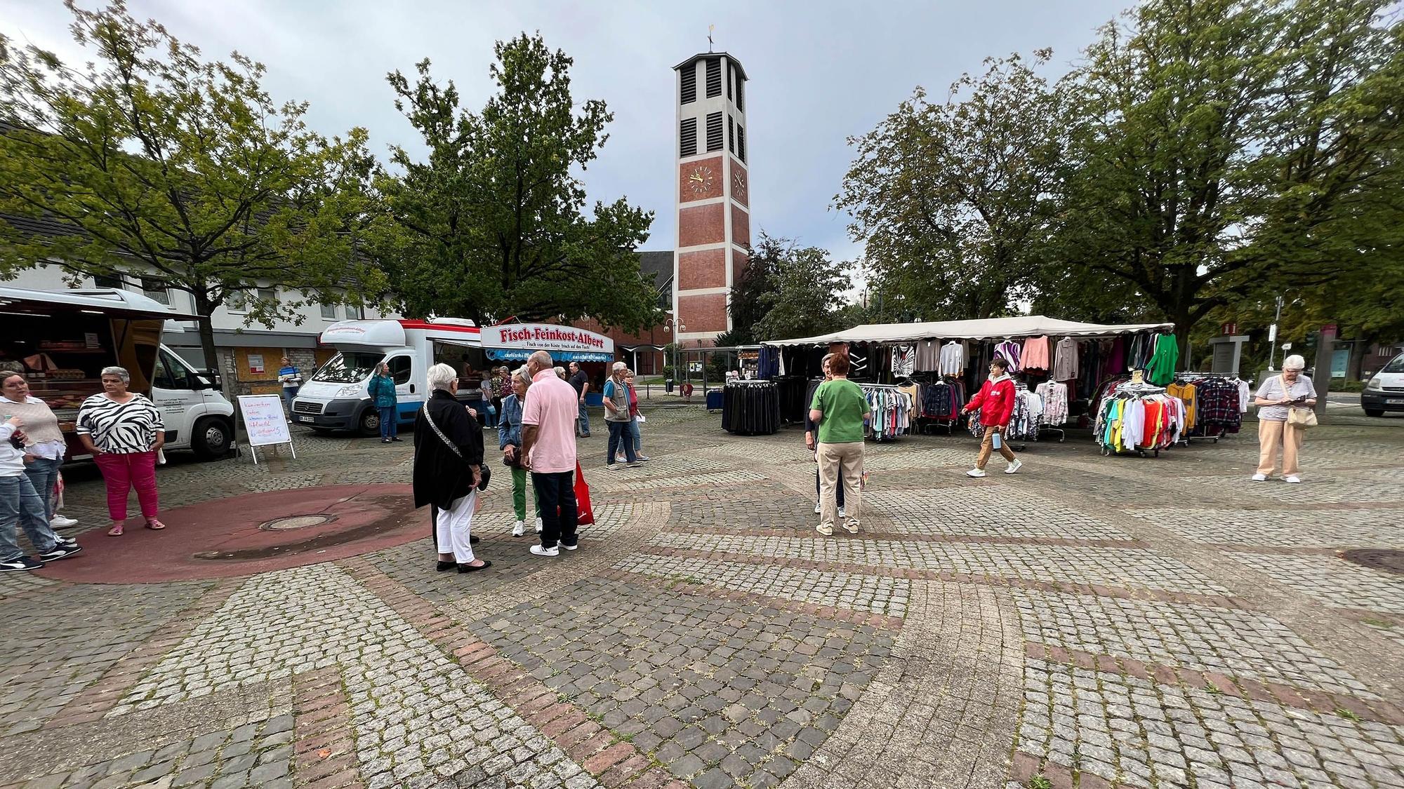 Einige Menschen stehen auf dem Marktplatz.