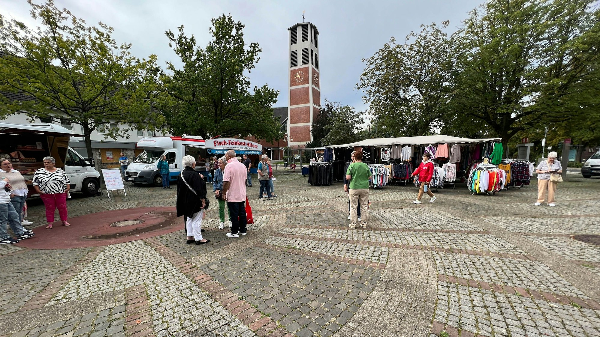 Einige Menschen stehen auf dem Marktplatz.