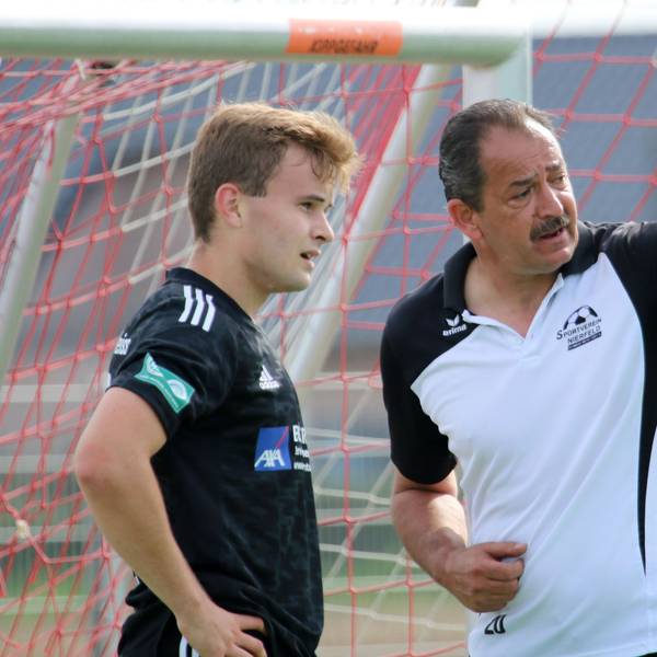 Ein Fußballtrainer gibt seinem Spieler Anweisungen.