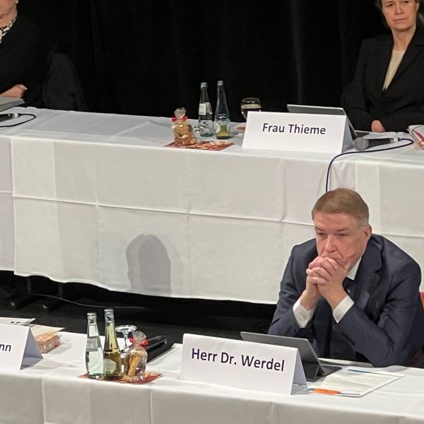 Rhein-Bergs Landrat Stephan Santelmann und Kreisdirektor Dr. Erik Werdel sitzen an einem Tisch auf einem Podium bei einer Kreistagssitzung.