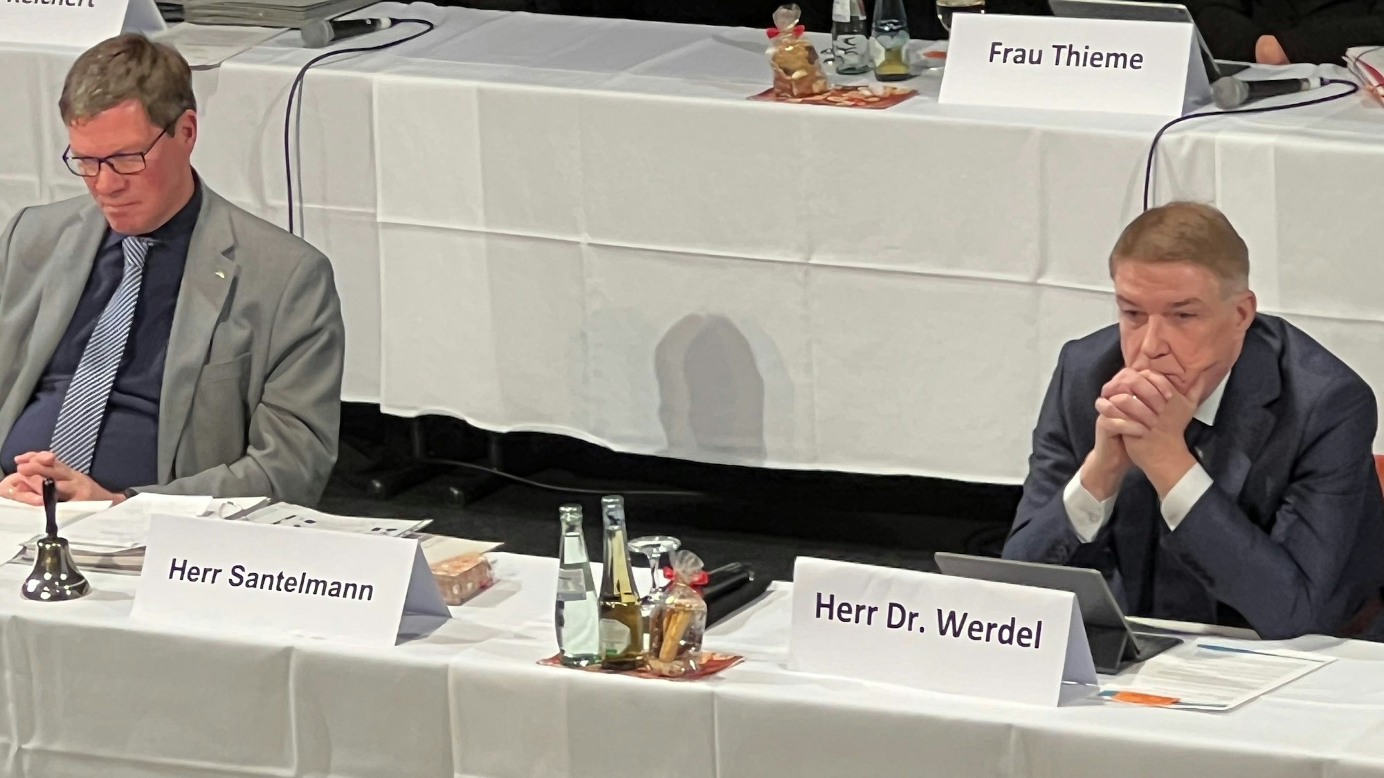 Rhein-Bergs Landrat Stephan Santelmann und Kreisdirektor Dr. Erik Werdel sitzen an einem Tisch auf einem Podium bei einer Kreistagssitzung.
