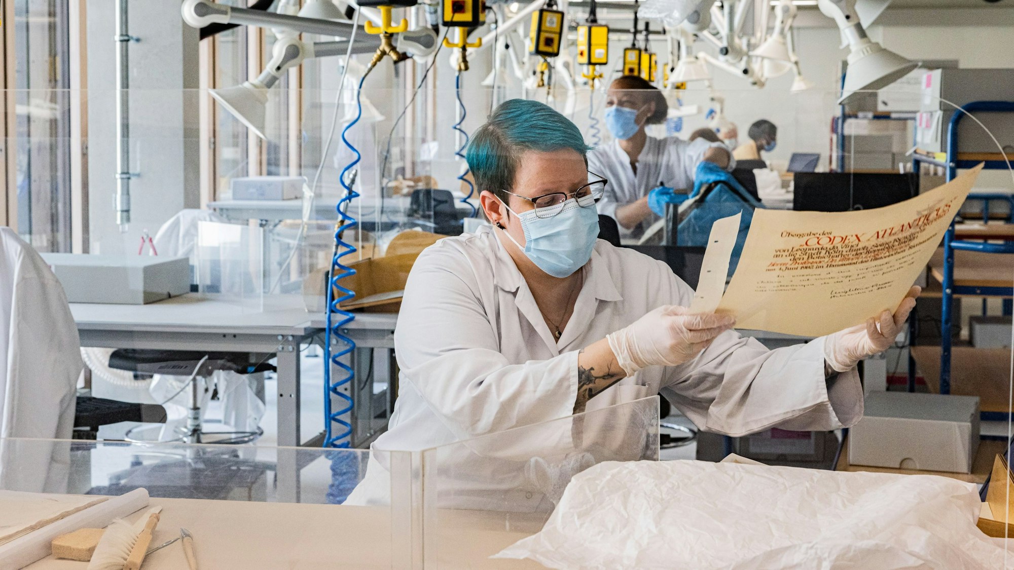 Eine Frau bewegt vorsichtig ein Dokument.