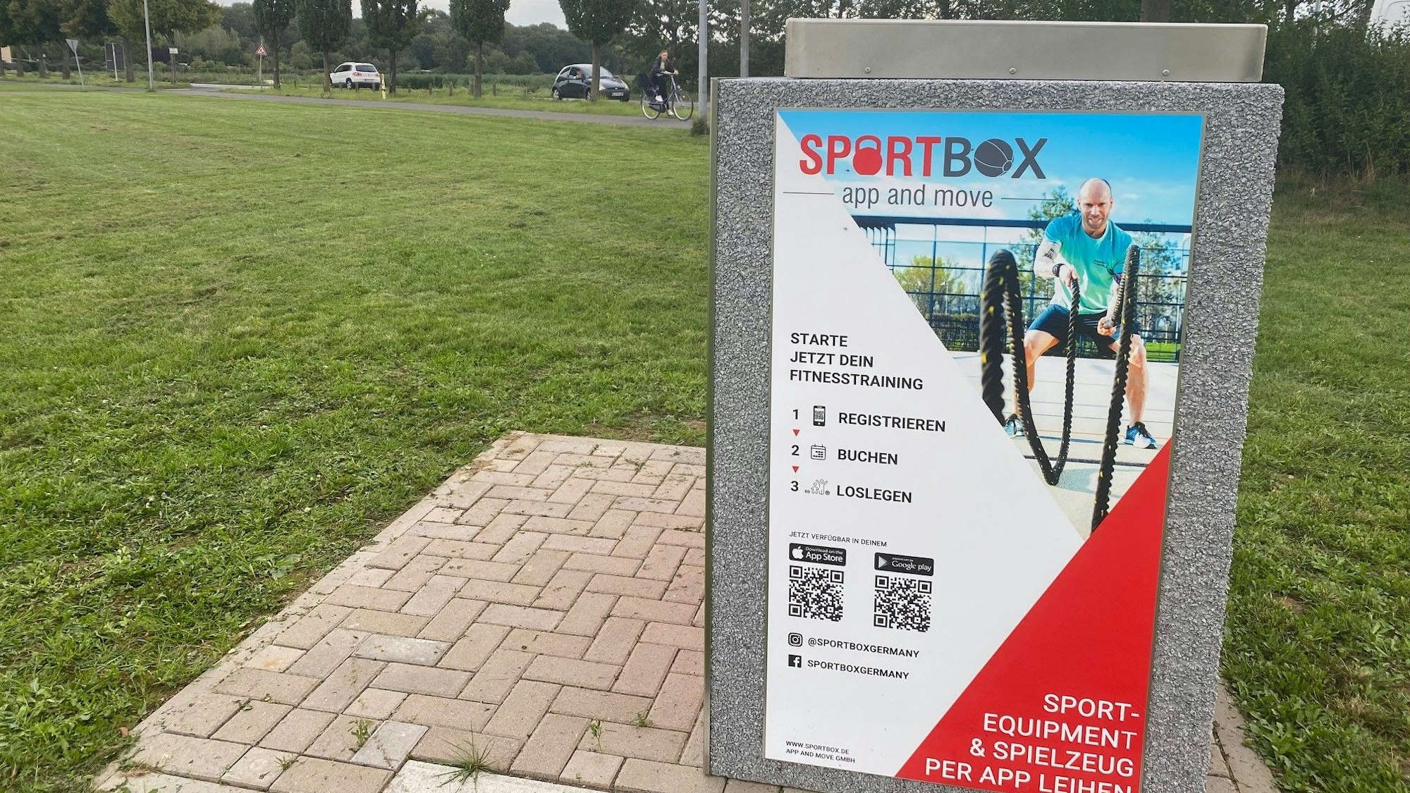 Zu sehen ist die mit Bedienungsinformationen beschriftete Sportbox auf der Freizeitwiese.