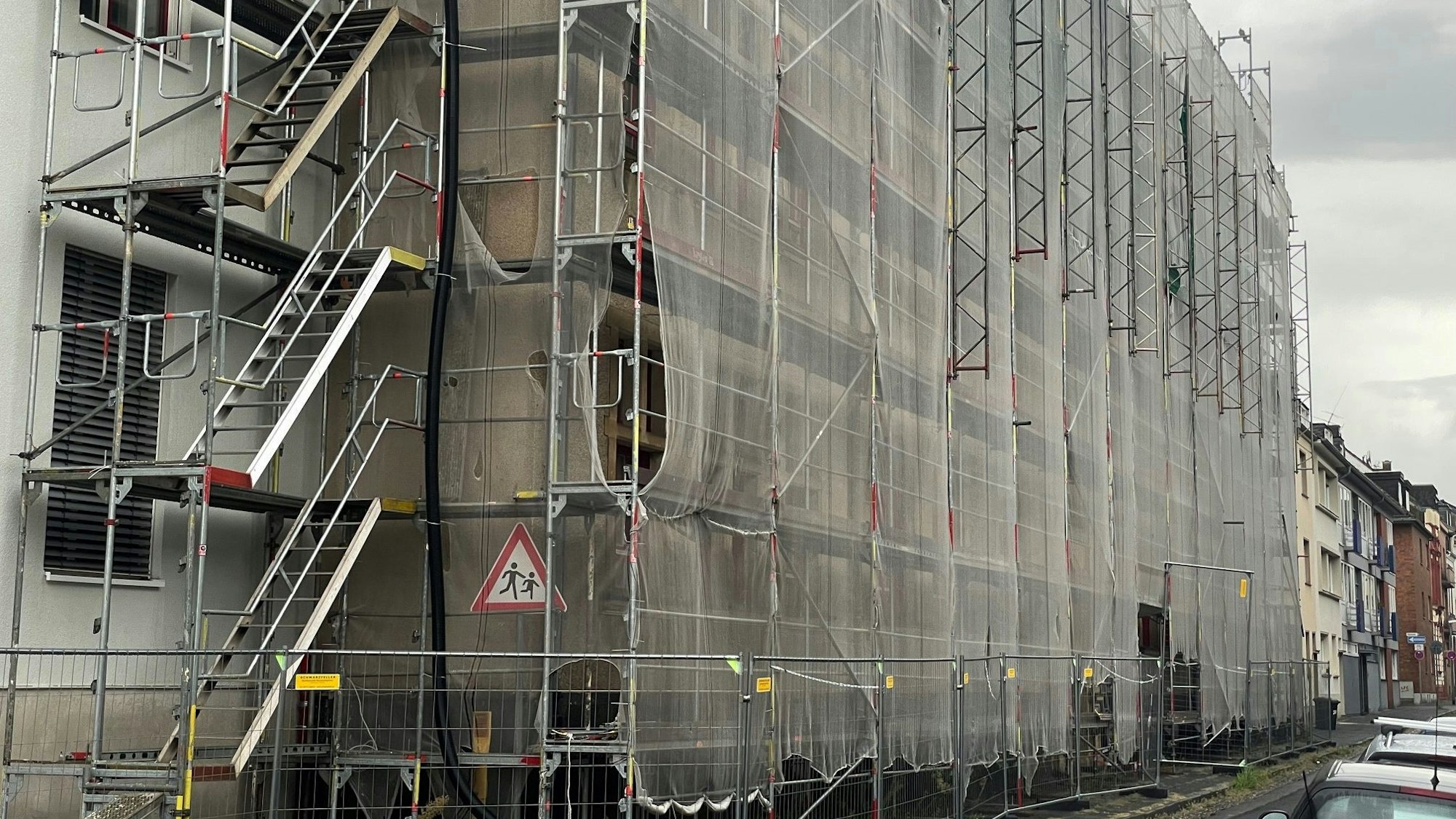 Das Bild zeigt die Fassade der Gesamtschule Euskirchen. Sie ist eingerüstet und mit einem Schutznetz umgeben.