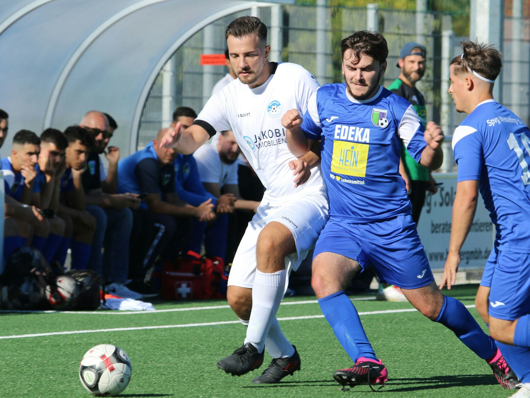 Drei Fußballer im Zweikampf.