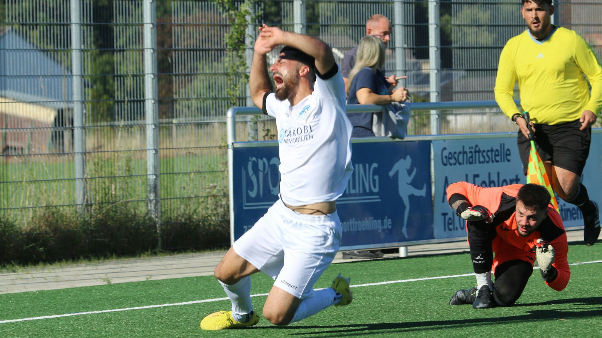 Bessenichs Stürmer fällt und schreit. Der Wesselinger Torhüter hat ihn getroffen.