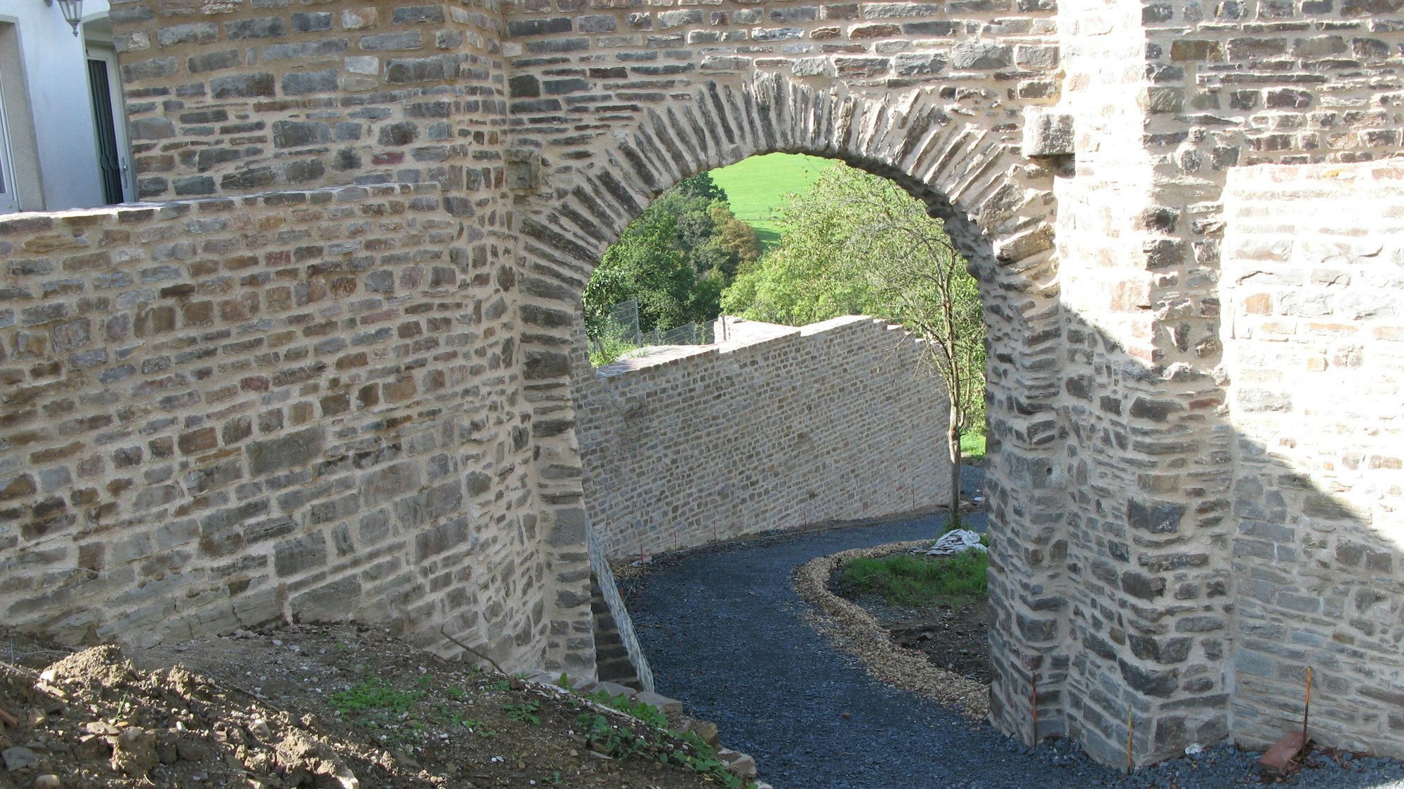 Das sanierte Kölner Tor mit Rundbogen in der Stadt Blankenberger Stadtmauer sieht fast wie frisch gemauert aus.