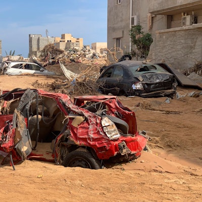 Zerstörte Autos liegen zwischen Gebäuden.