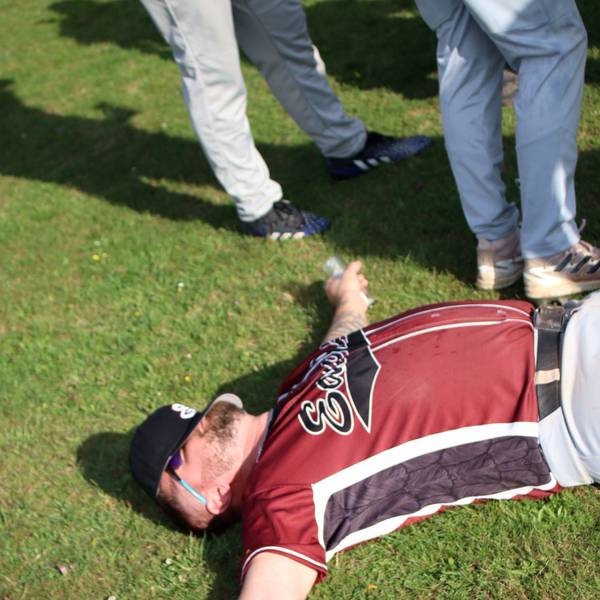 Ein Baseball-Spieler liegt mit ausgebreiteten Armen auf dem Gras.