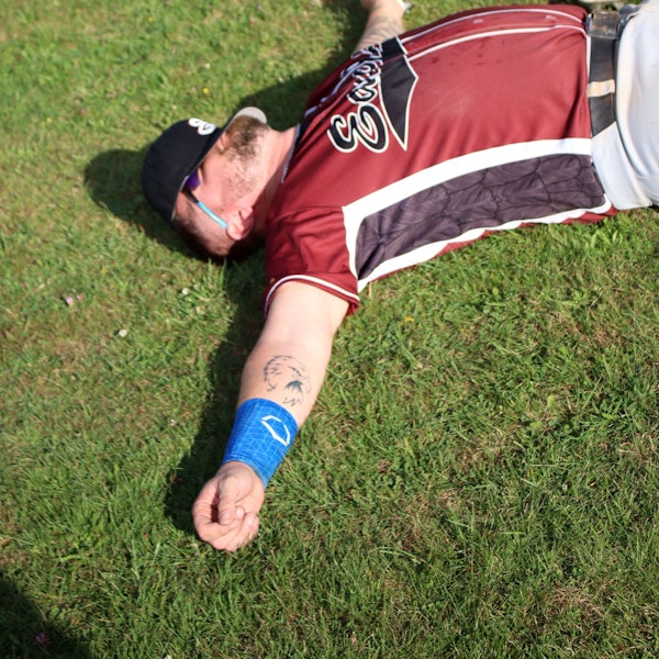 Ein Baseball-Spieler liegt mit ausgebreiteten Armen auf dem Gras.
