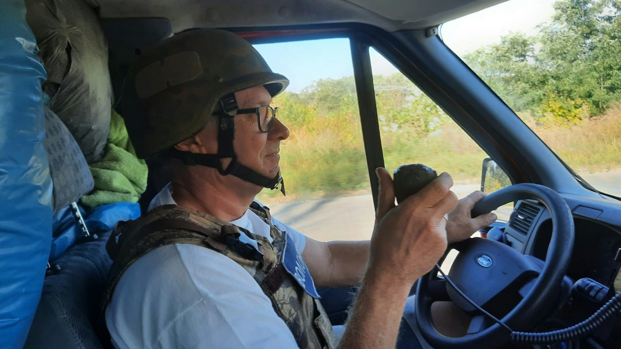 Rheinbach hilft erlebt bei Kupjansk Raketenbeschuss und gibt Rheinbacher Feuerwehrauto ab. Hier Alfred Eich am Steuer des Vereins-Transporters mit Helm.