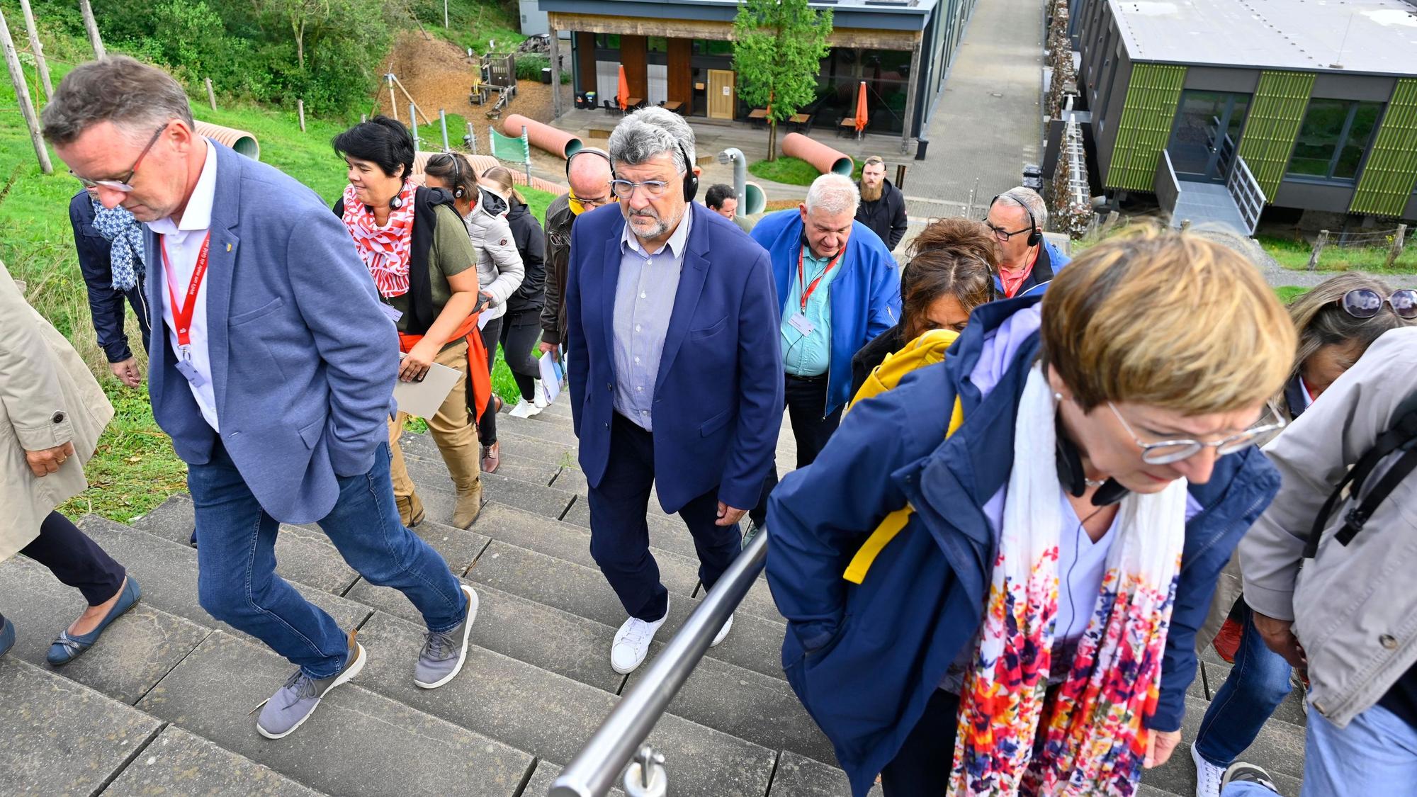 La Roches Bürgermeister Luc Bouard (Mitte) erklimmt Treppen auf Metabolon.