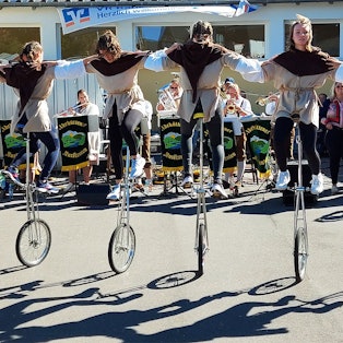 Das Foto zeigt sechs Akteure auf Hochrädern.