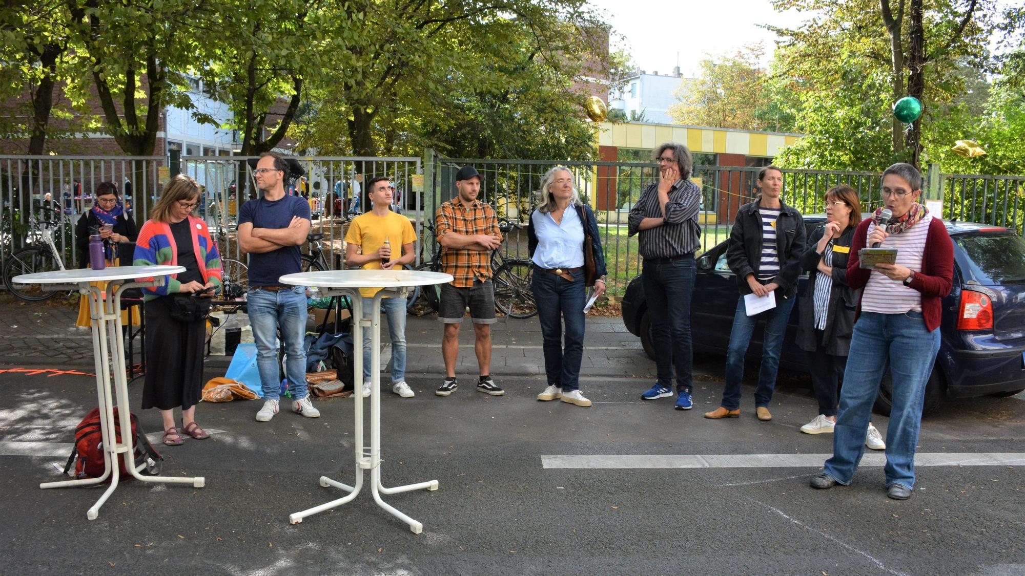Neun Menschen stehen auf der Burgunderstraße und diskutieren.