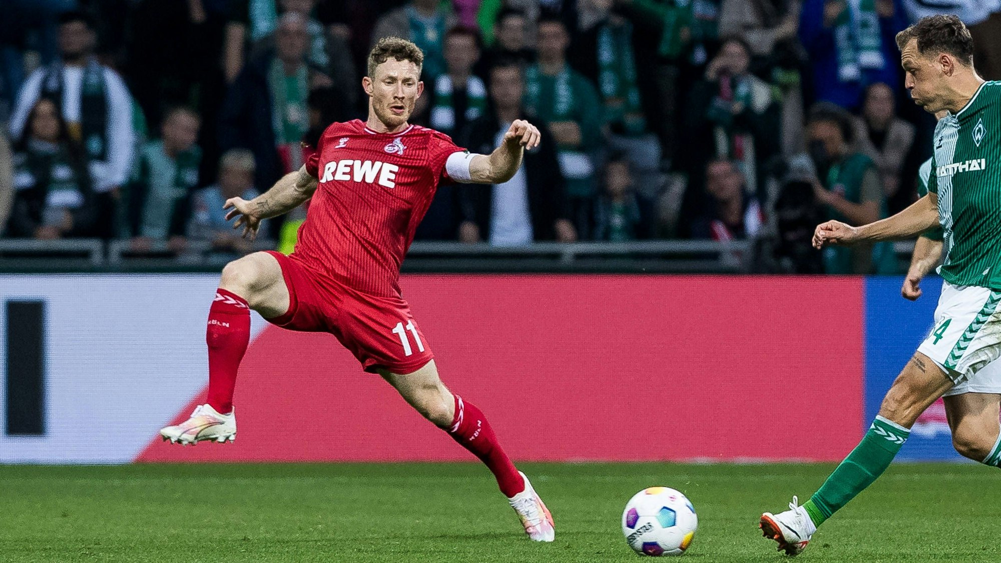 Florian Kainz steht auf dem Spielfeld und versucht den Ball abzuwehren.