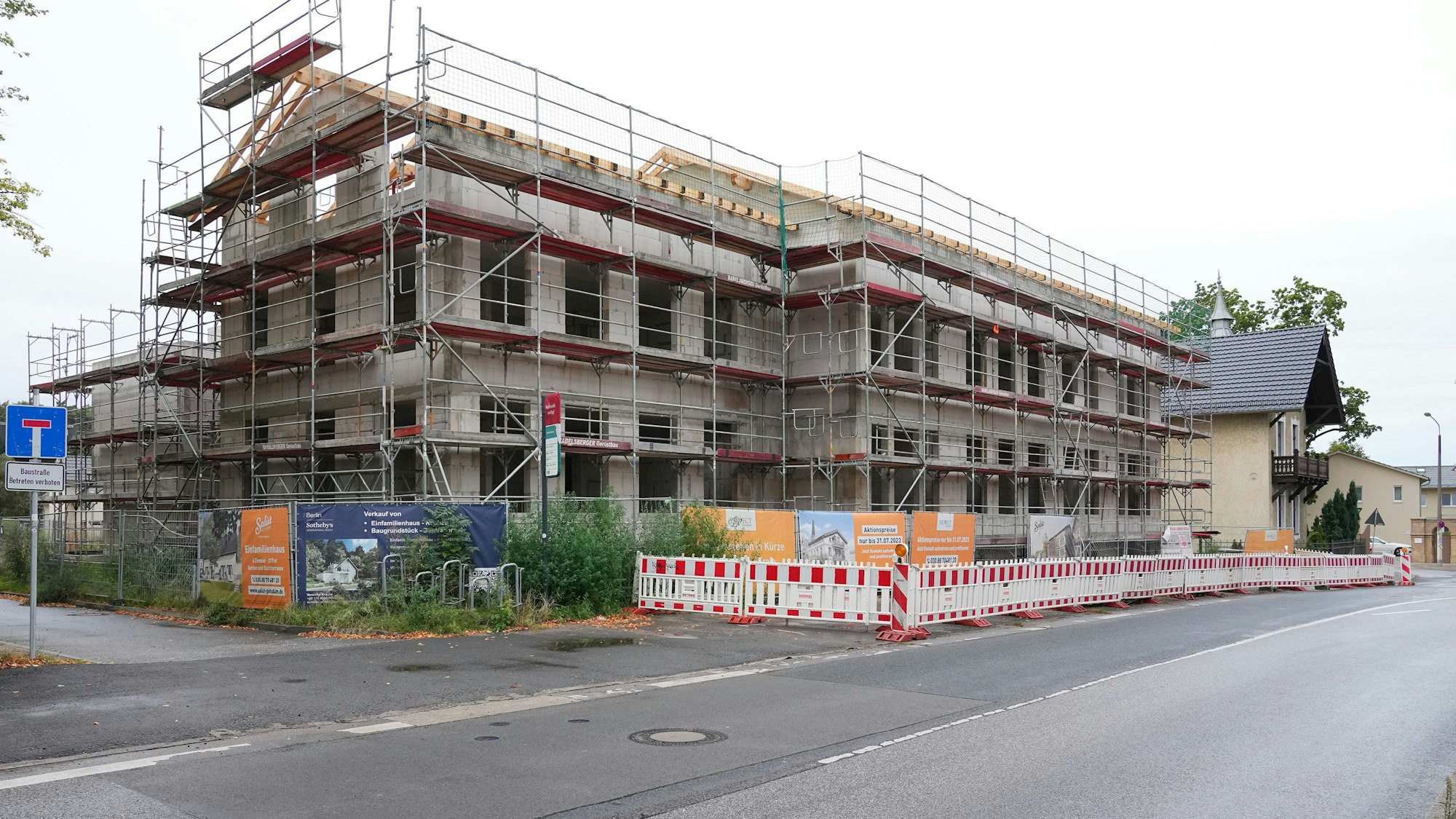 Ein Baugerüst steht an dem Rohbau eines Mehrfamilienhauses im Potsdamer Ortsteil Bornim. Wie findet Deutschland wieder Wohnraum? Um diese Frage geht es am Montag im Kanzleramt.
