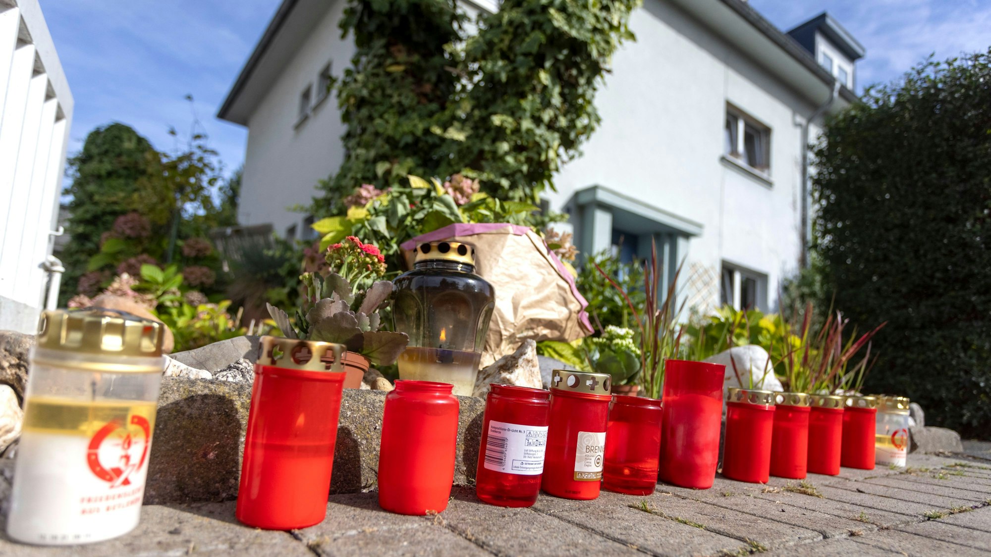 Kerzen stehen auf der Römerstrasse in Rodenkirchen. Ein 19-Jähriger wurde in Köln erstochen, ein Verdächtiger sitzt in U-Haft.