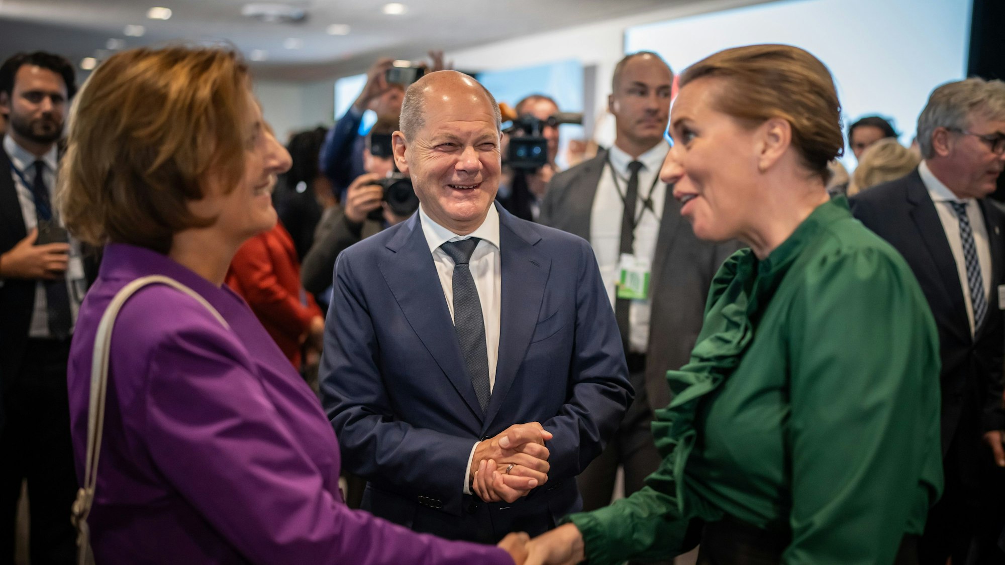 Bundeskanzler Olaf Scholz (SPD), lacht, während seine Frau Britta Ernst Mette Frederiksen, Ministerpräsidentin von Dänemark, begrüßt.
