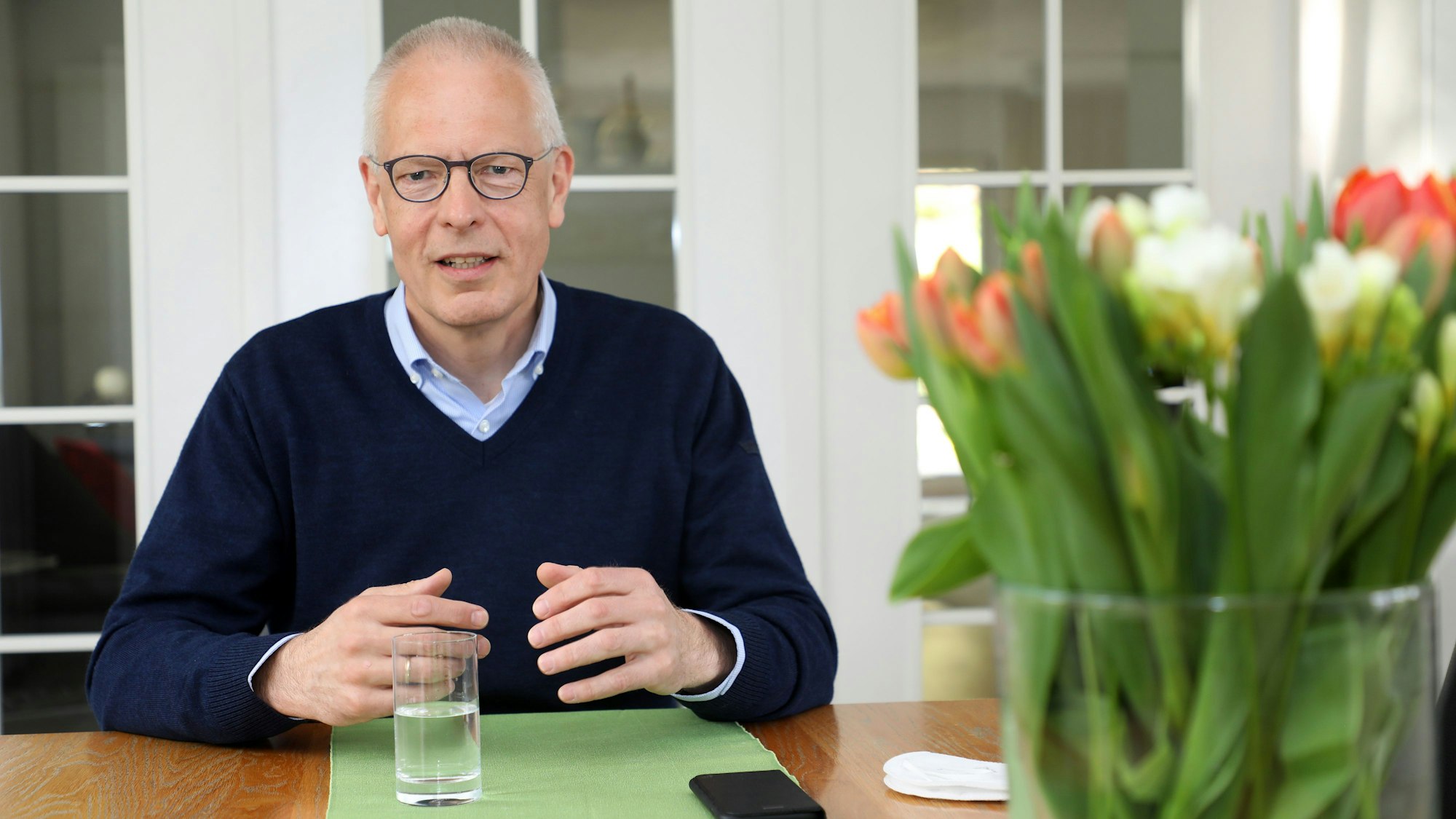 Dr. Hermann-Josef Tebroke sitzt am Wohnzimmertisch seines Hauses in Lindlar.