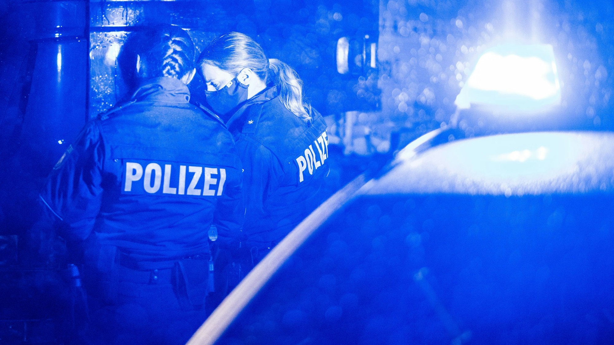 Polizisten kontrollieren einen LKW an einer Autobahn-Kontrollstelle.