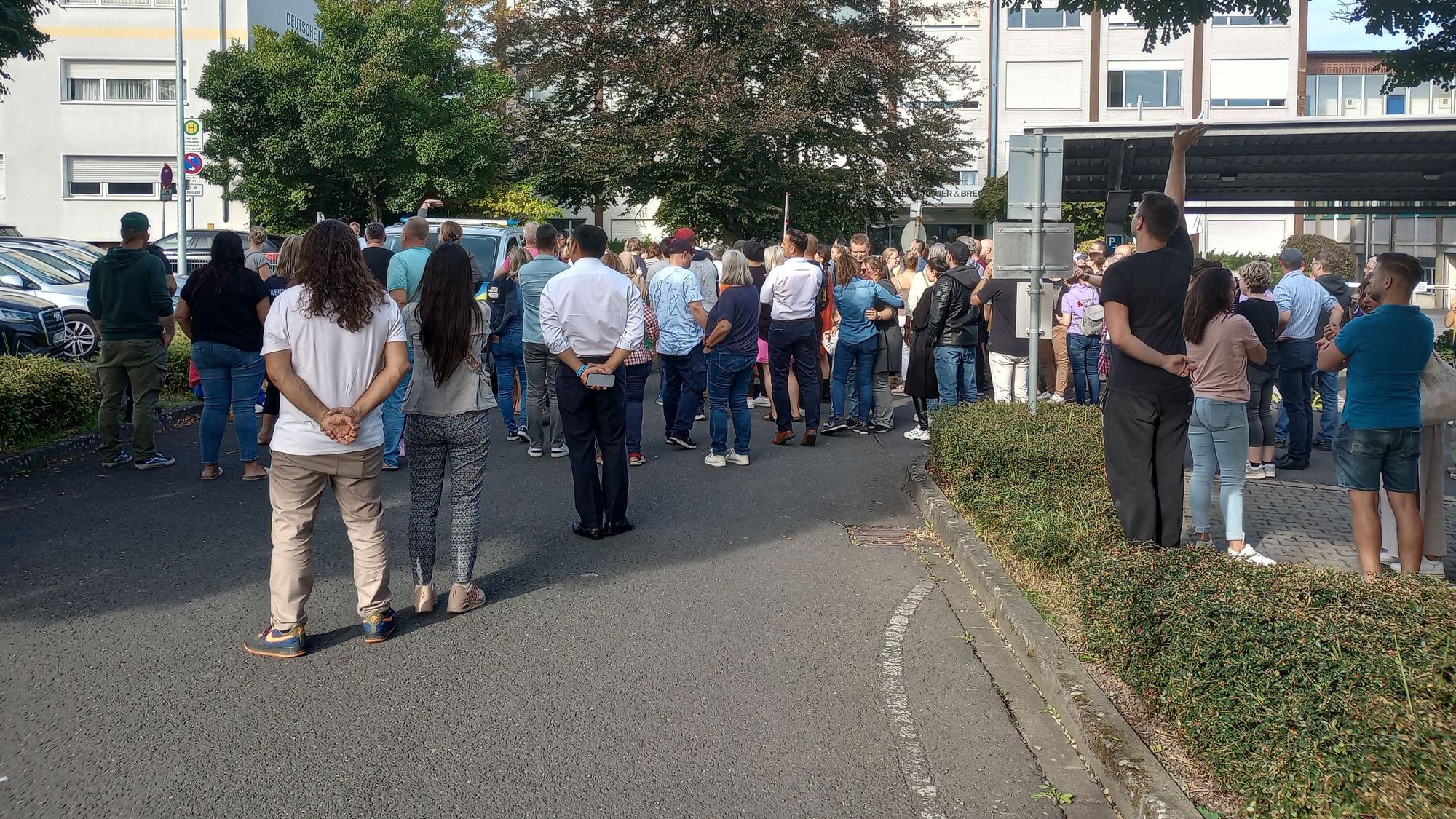 Eltern warten auf einem nahegelegenen Parkplatz auf ihre Kinder
