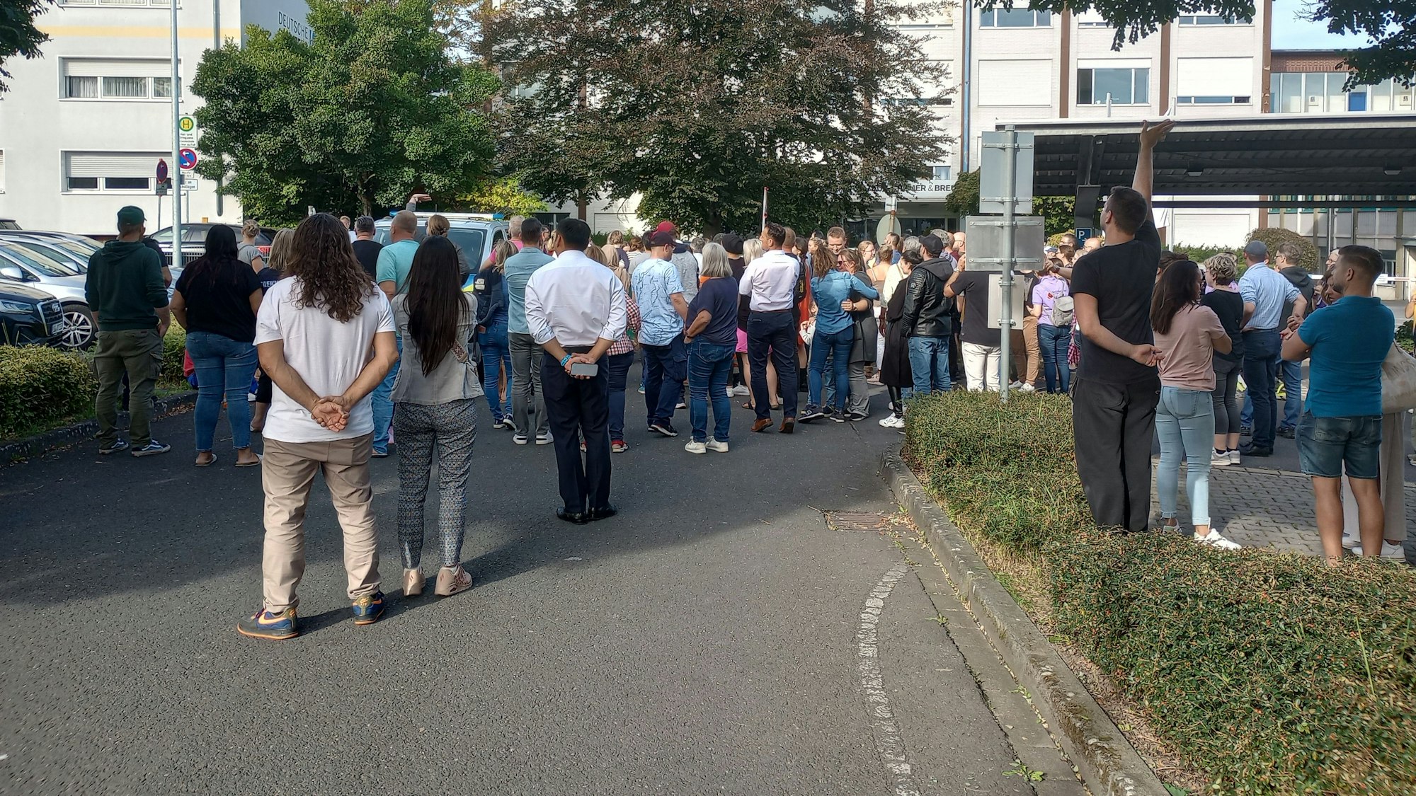 Eltern warten auf einem nahegelegenen Parkplatz auf ihre Kinder