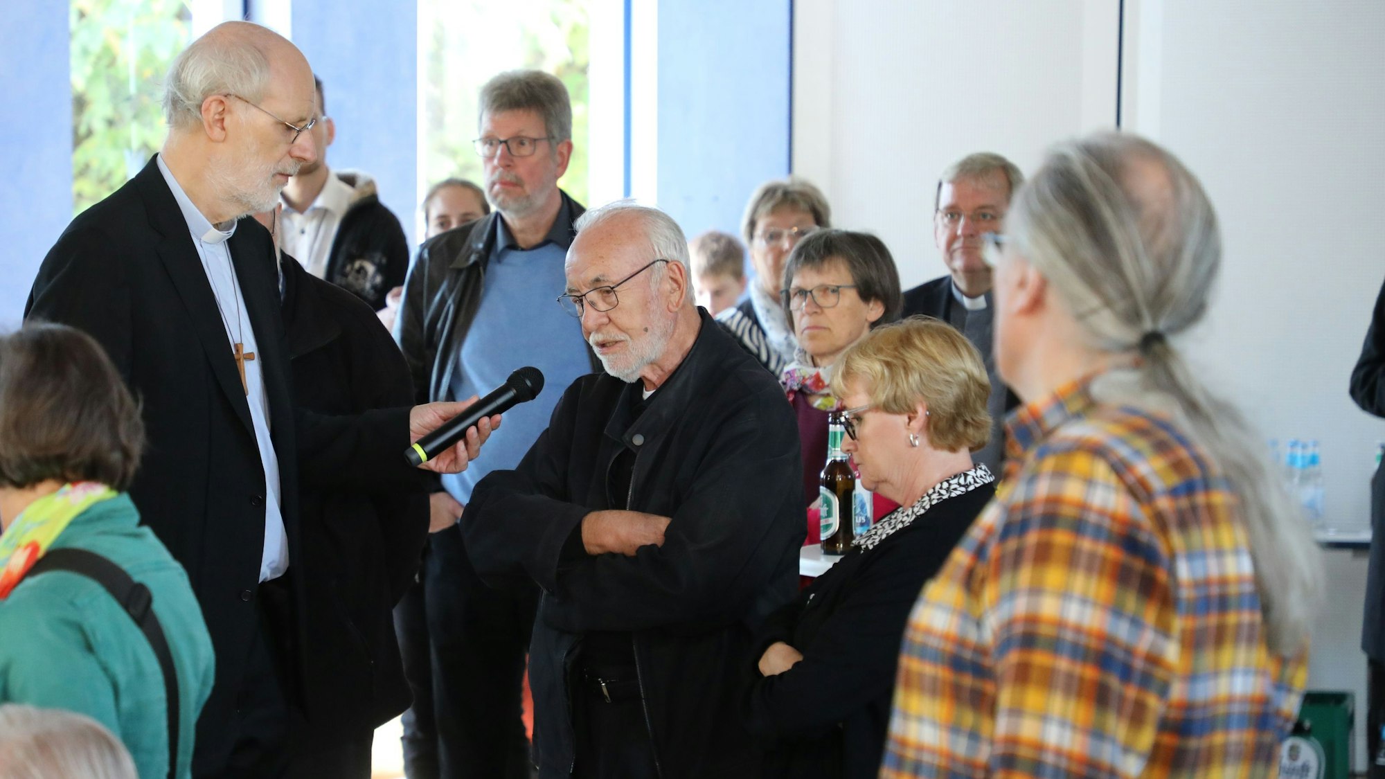 Weihbischof Ansgar Puff steht mit einem Mikrofon im Publikum.