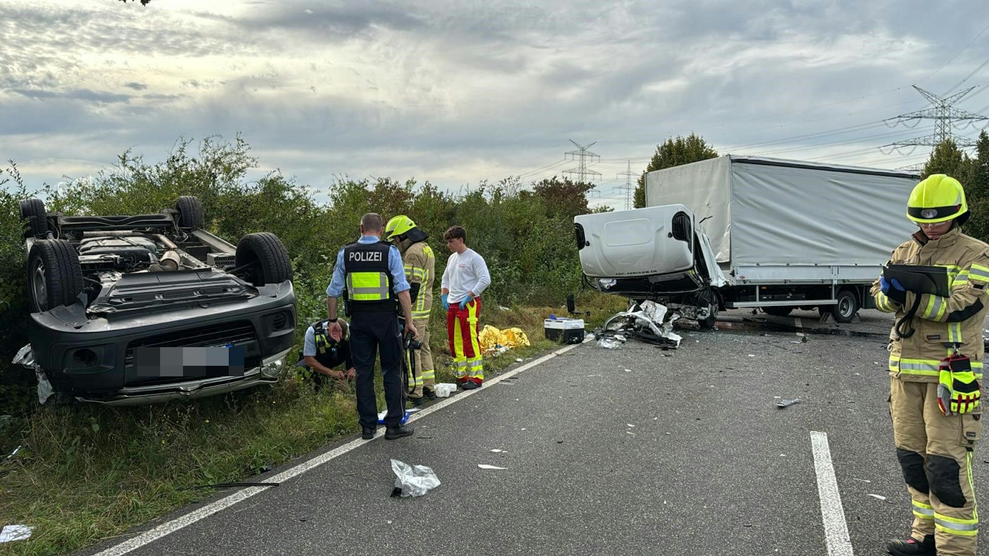Das Bild zeigt einen überschlagenen Pkw und einen querstehenden Lkw.