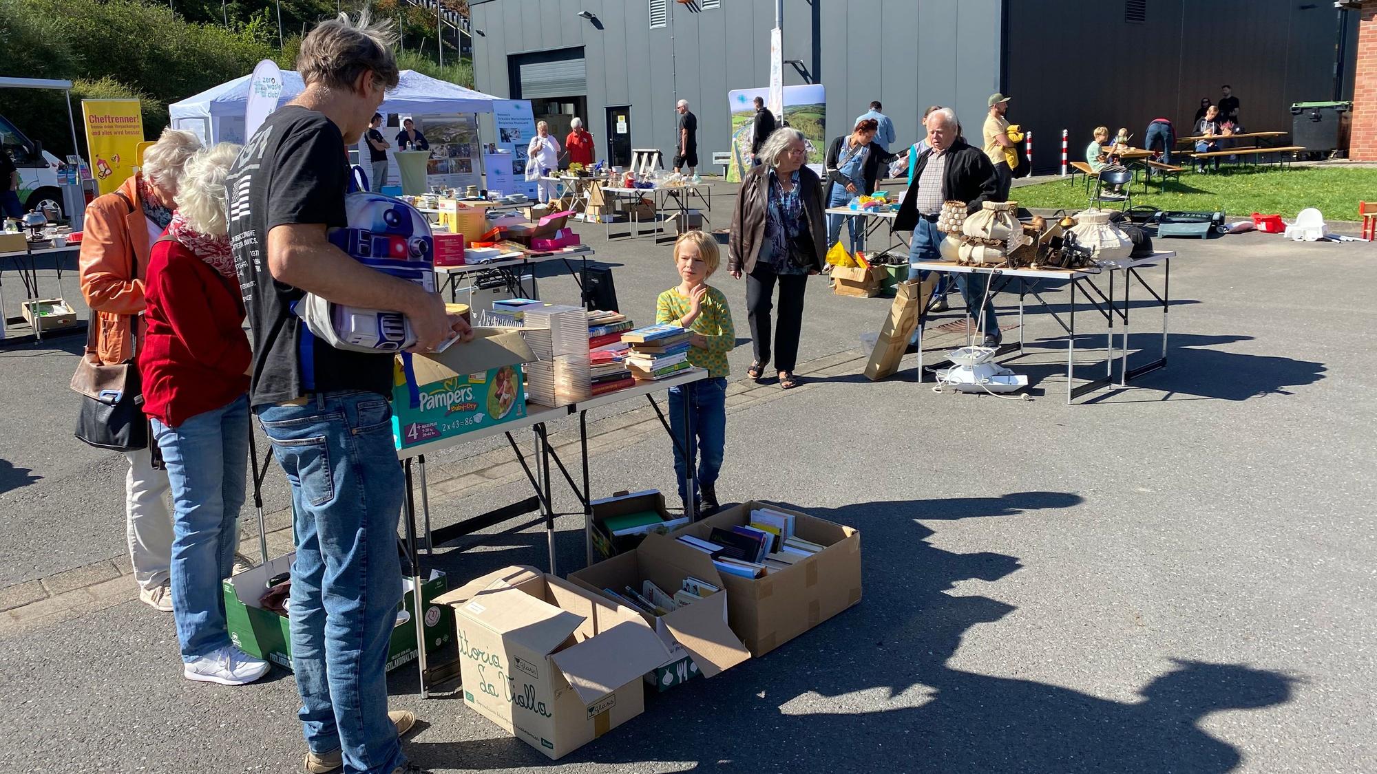 Auf Metabolon in Lindlar fand der Tauschrausch statt. Menschen schauen sich an verschiedenen Tischen um, an denen, wie auf einem Flohmarkt, Dinge angeboten wurden.
