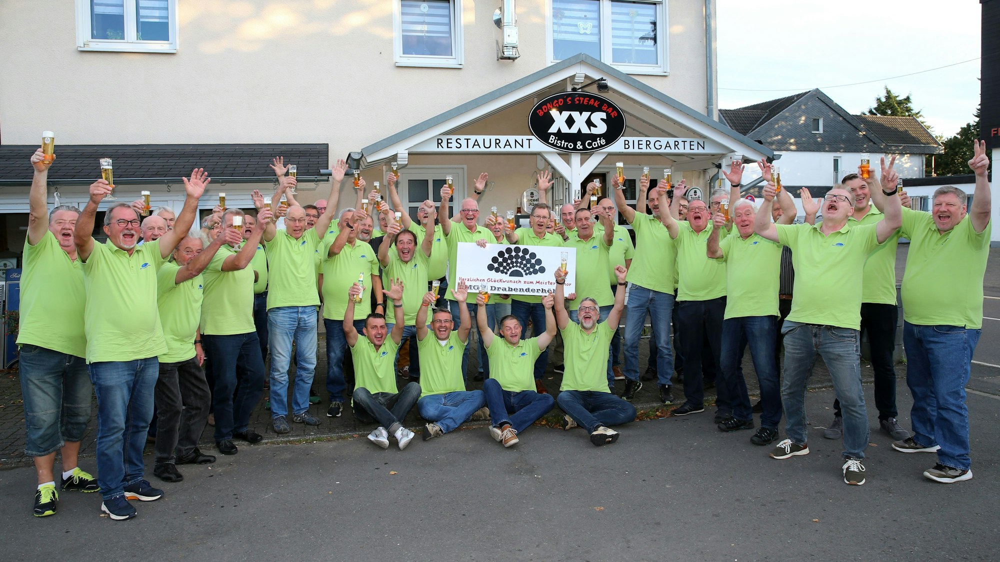 Eine Gruppe von Männern steht im Halbkreis und jubelt.