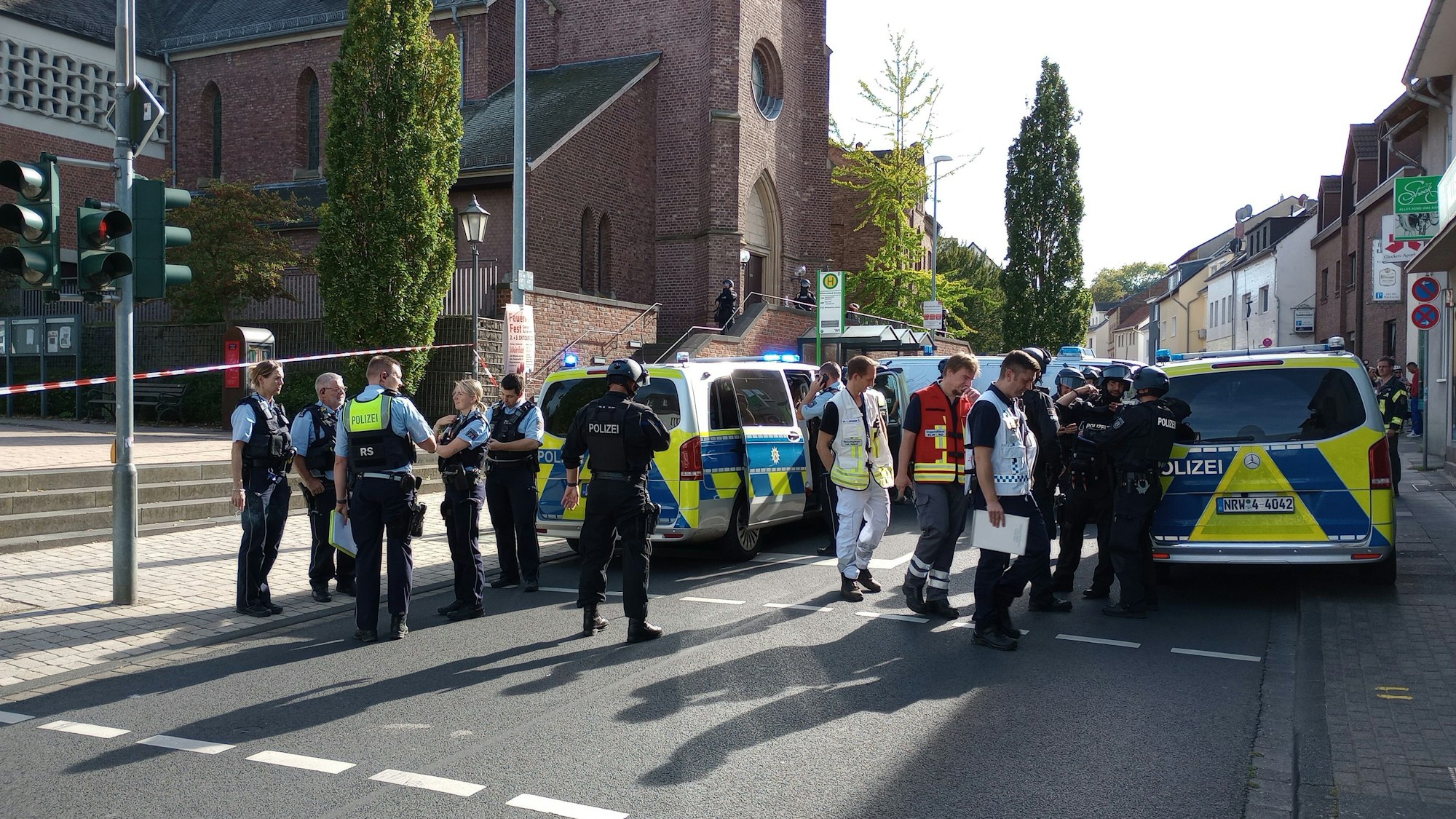 Einsatzkräfte stehen vor der katholischen Kirche Witterschlick