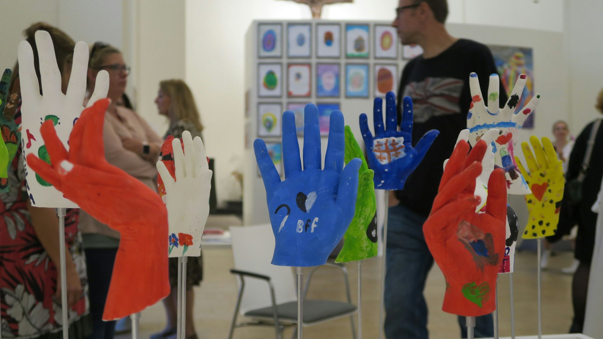 Bunt bemalte Handabdrücke werden ausgestellt.