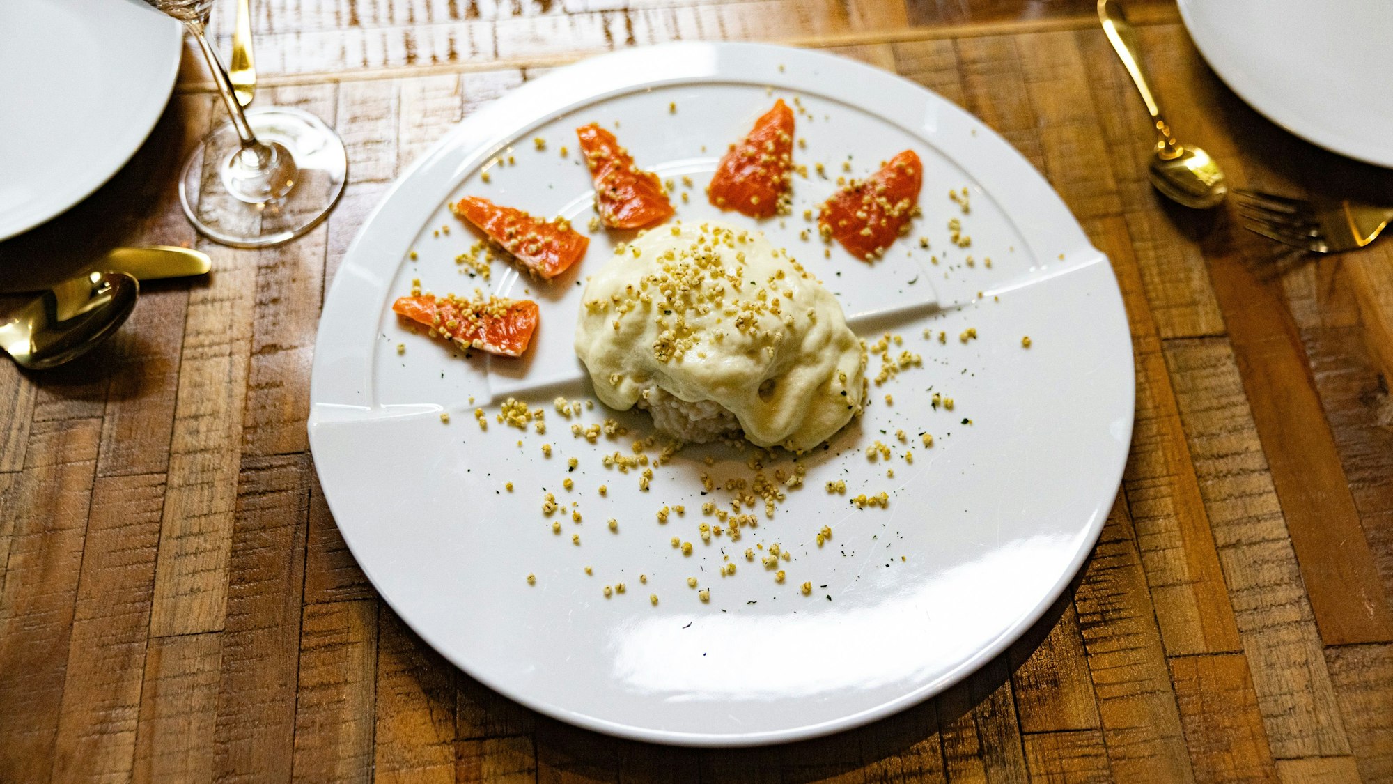 Sashimi der Dry Aged Lachsforelle mit Graupensalat, Liebstöckelschaum und gepufften Graupen.