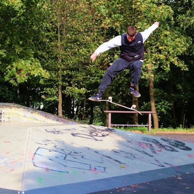 Jan Hochgürtel zeigt auf einer Skate-Anlage in Euskirchen Tricks mit dem Skateboard. Hier springt er hoch und lässt das Board unter seinen Füßen in der Luft rotieren.