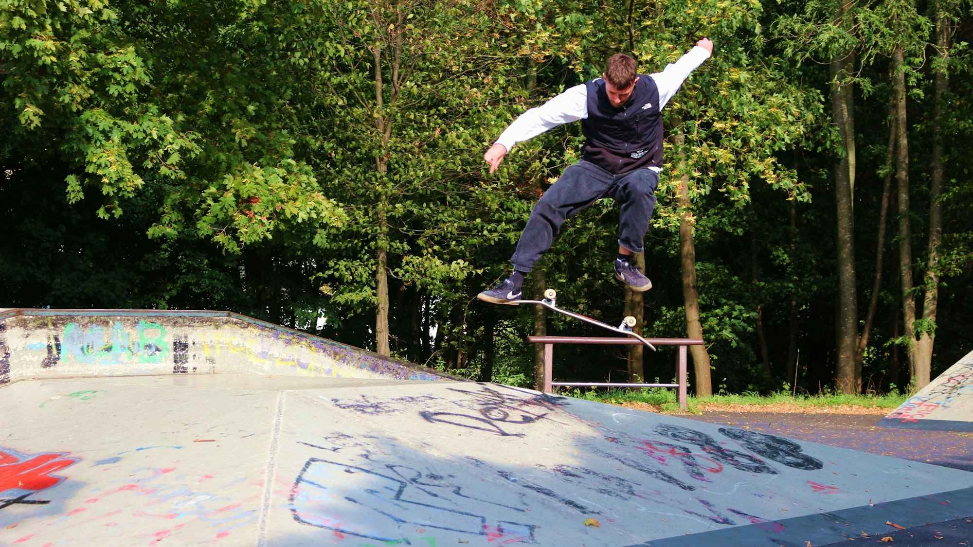 Jan Hochgürtel zeigt auf einer Skate-Anlage in Euskirchen Tricks mit dem Skateboard. Hier springt er hoch und lässt das Board unter seinen Füßen in der Luft rotieren.
