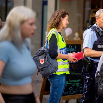 Das Bild zeigt Markus Braun in Polizeiuniform und Simone Becker in gelber Warnweste im Gespräch mit zwei Frauen.