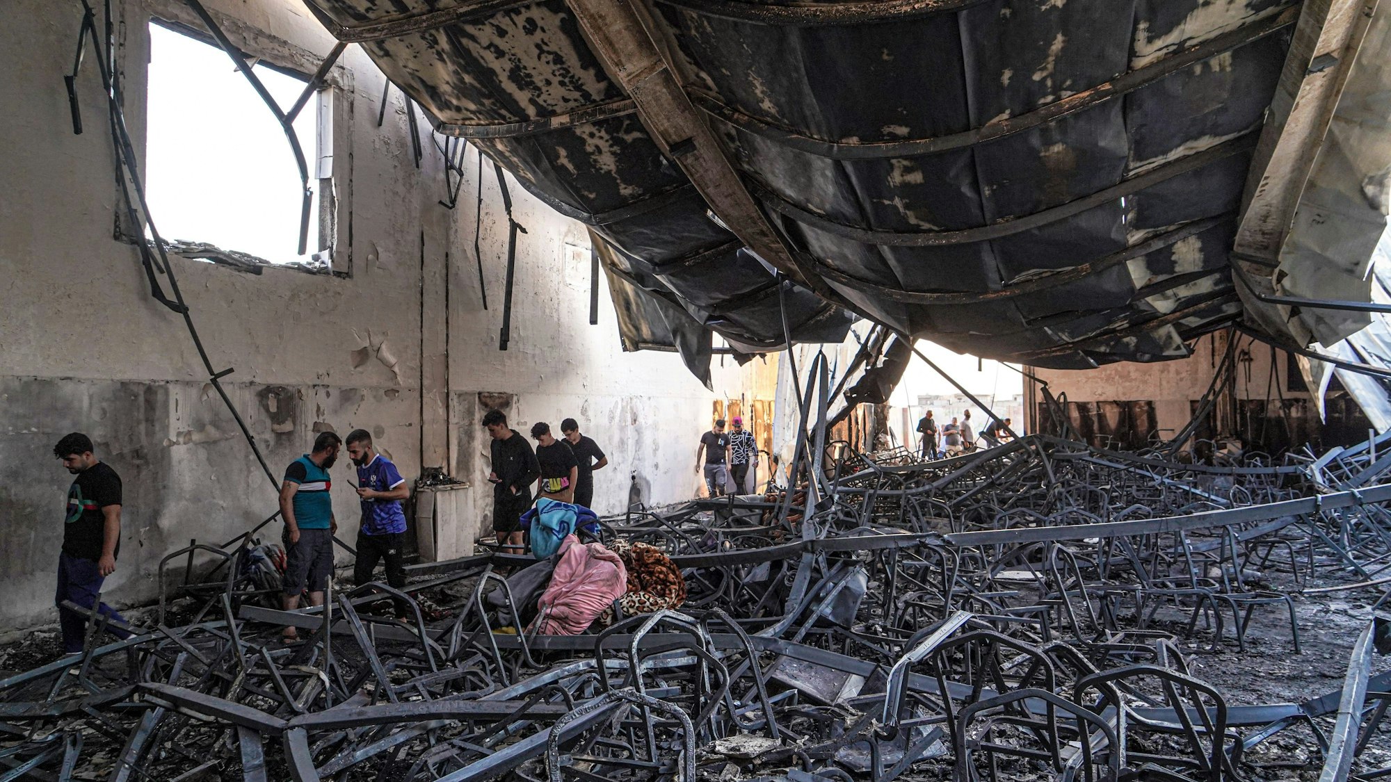 27.09.2023, Irak, Hamdaniya: Ein Blick in die eingestürzte und ausgebrannte Halle, in der ein Brand während einer Hochzeitsfeier ausgebrochen war. Bei einem Brand bei einer Hochzeitsfeier im Irak sind mehr als 100 Menschen ums Leben gekommen. Leicht entflammbares Material in der Halle ließ diese in kurzer Zeit in Flammen aufgehen und einstürzen. Al-Hamdanija liegt in der Nähe von Mossul im Nordwesten des Landes. Foto: Ismael Adnan/dpa +++ dpa-Bildfunk +++