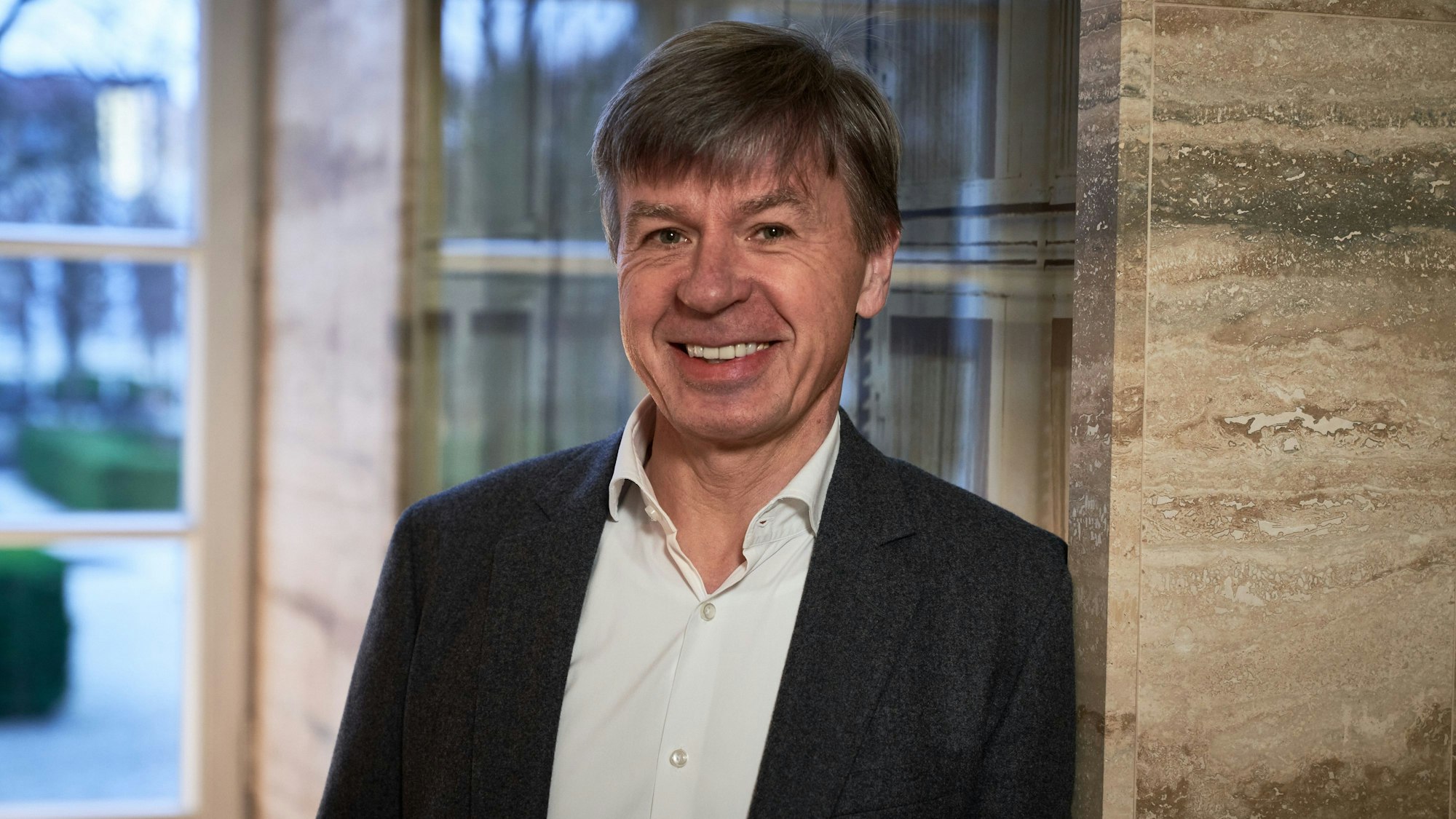 Spitzenkoch Joachim Wissler lehnt an einer Wand im Grandhotel Schloss Bensberg.